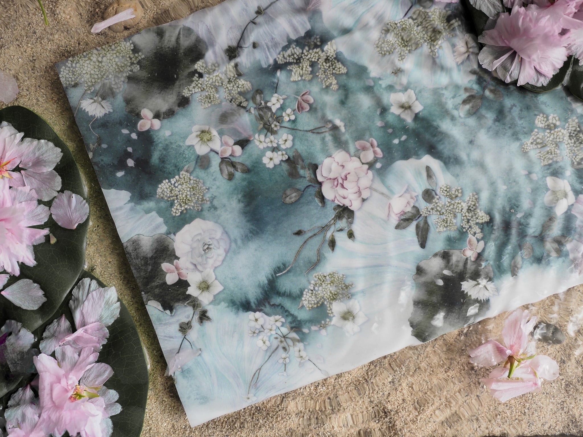 Ethereal watercolor floral pattern featuring pale pink and white cherry blossoms and delicate white clusters against a dreamy teal and soft blue background.