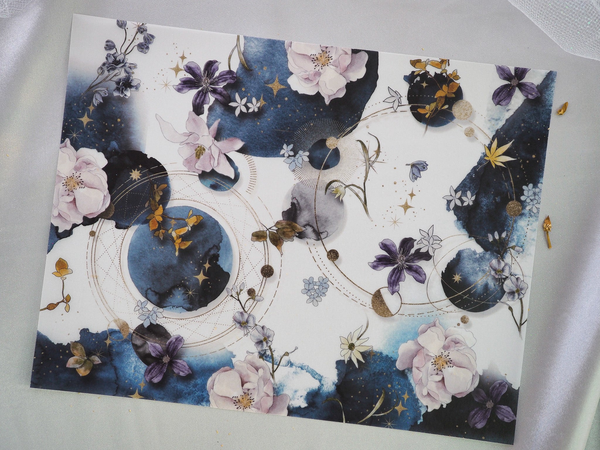 Ethereal celestial pattern featuring deep indigo night skies, watercolor flowers in soft hues, gold stars, and astronomical constellations.
