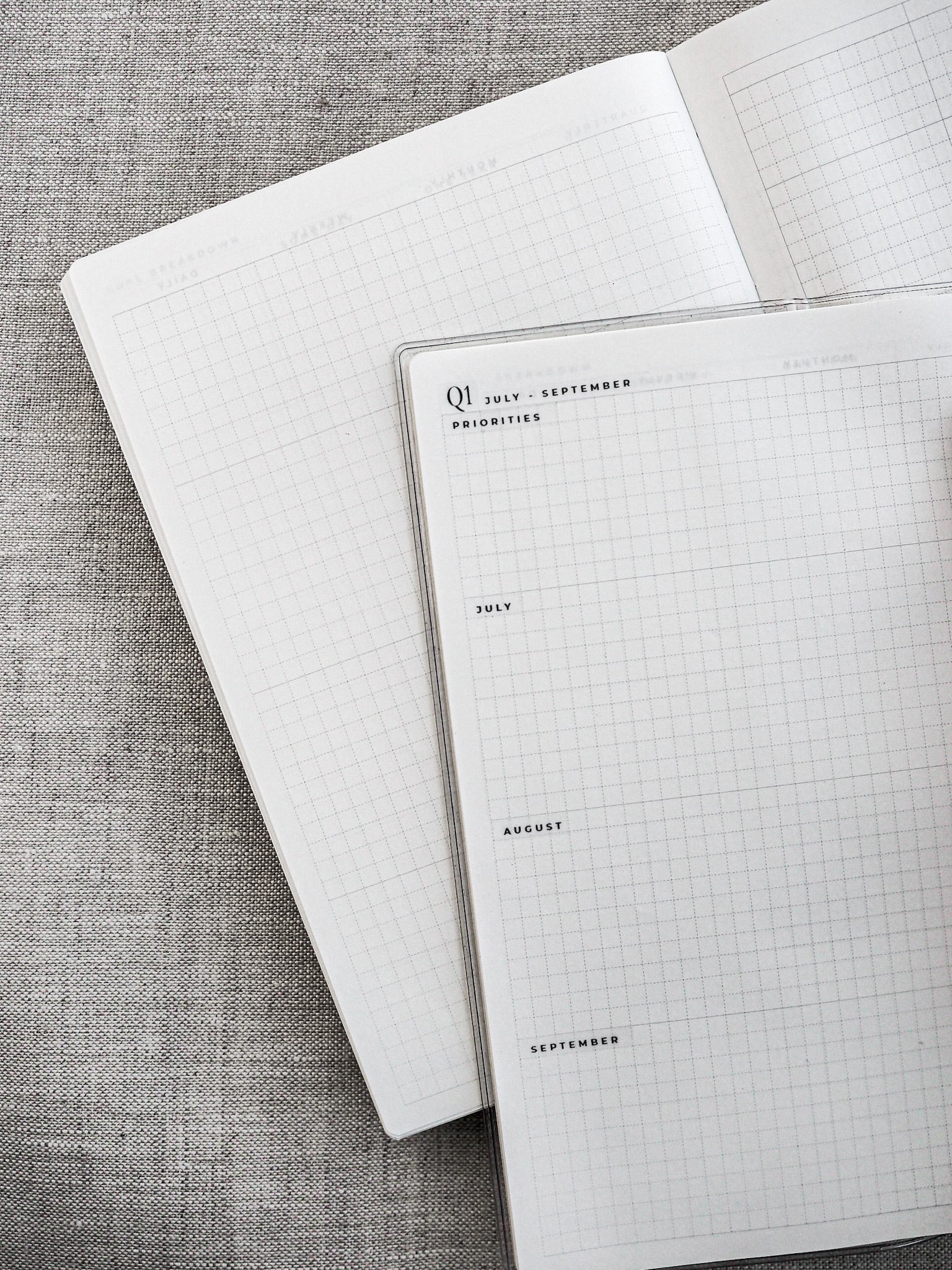 Structured, gridded planner pages designed for quarterly organization, featuring clear headings for Q1 and months like July, August, and September.