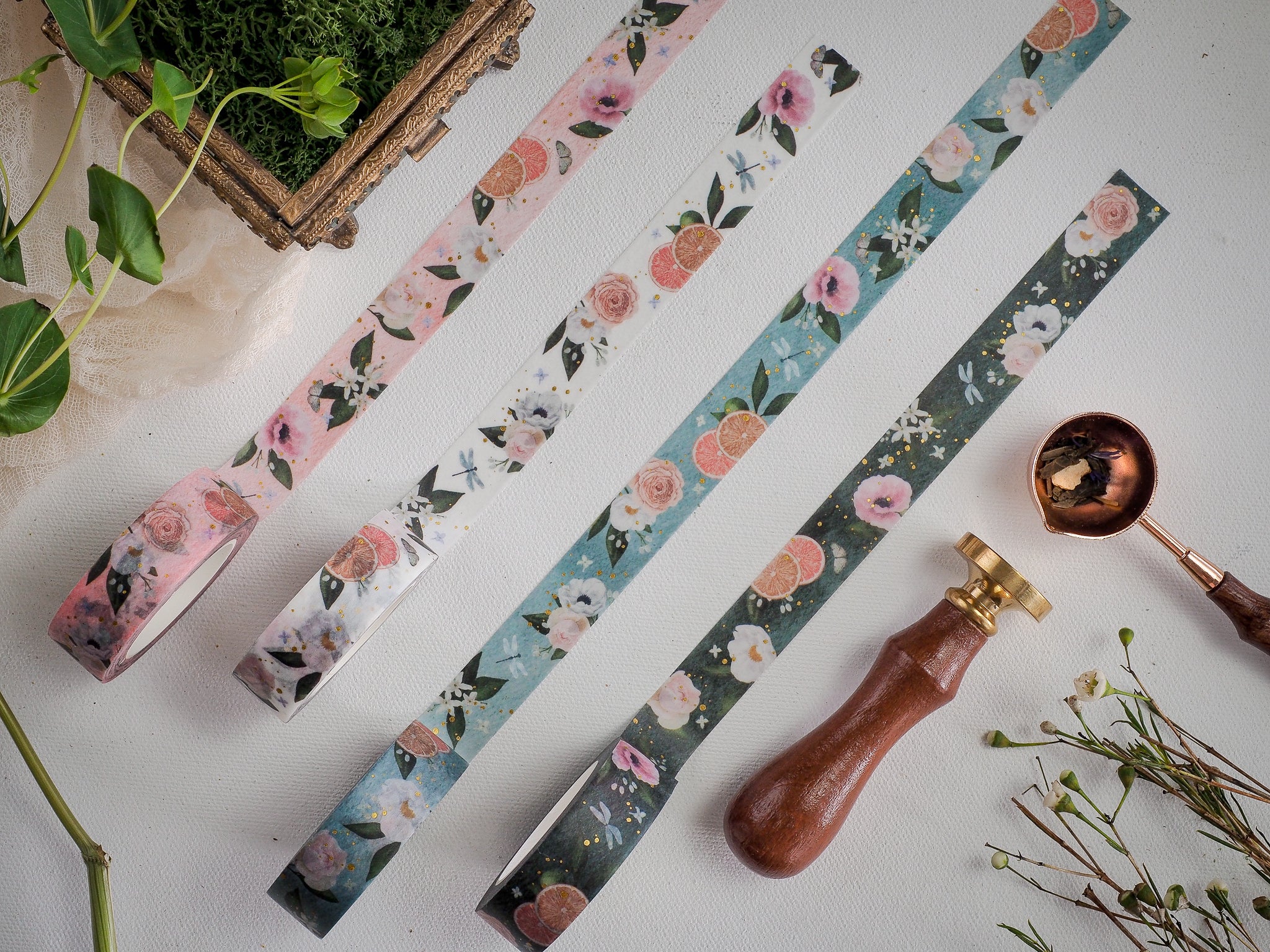 Three decorative strips of floral washi tape are displayed, featuring varied watercolor patterns of soft pinks, blues, and white blossoms perfect for crafting.
