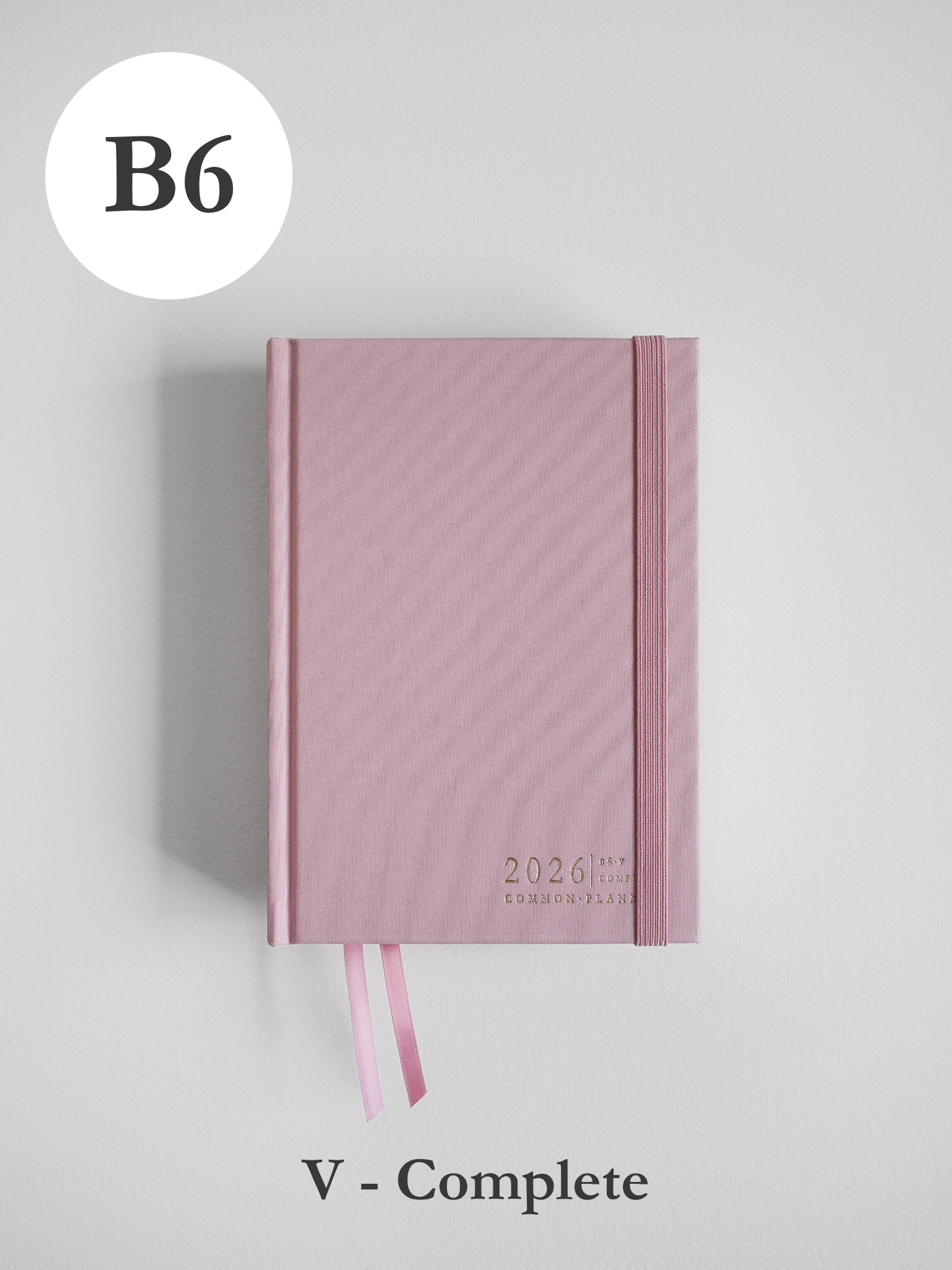 Soft dusty rose B6 common planner for 2026, featuring a subtle ribbed cover design, elastic closure, and attached matching pink ribbon bookmarks.
