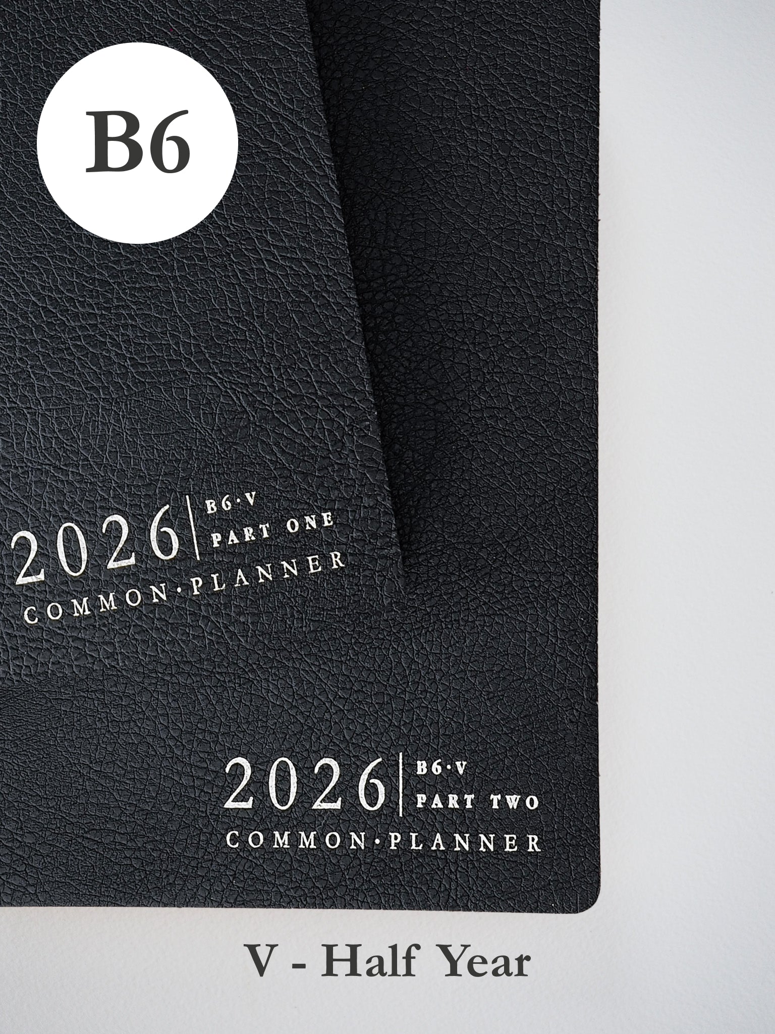 Matte black B6 planner bundle for 2026, displaying clean, minimalist white text identifying "Part One" and "Part Two" for a coordinated half-year planning system.