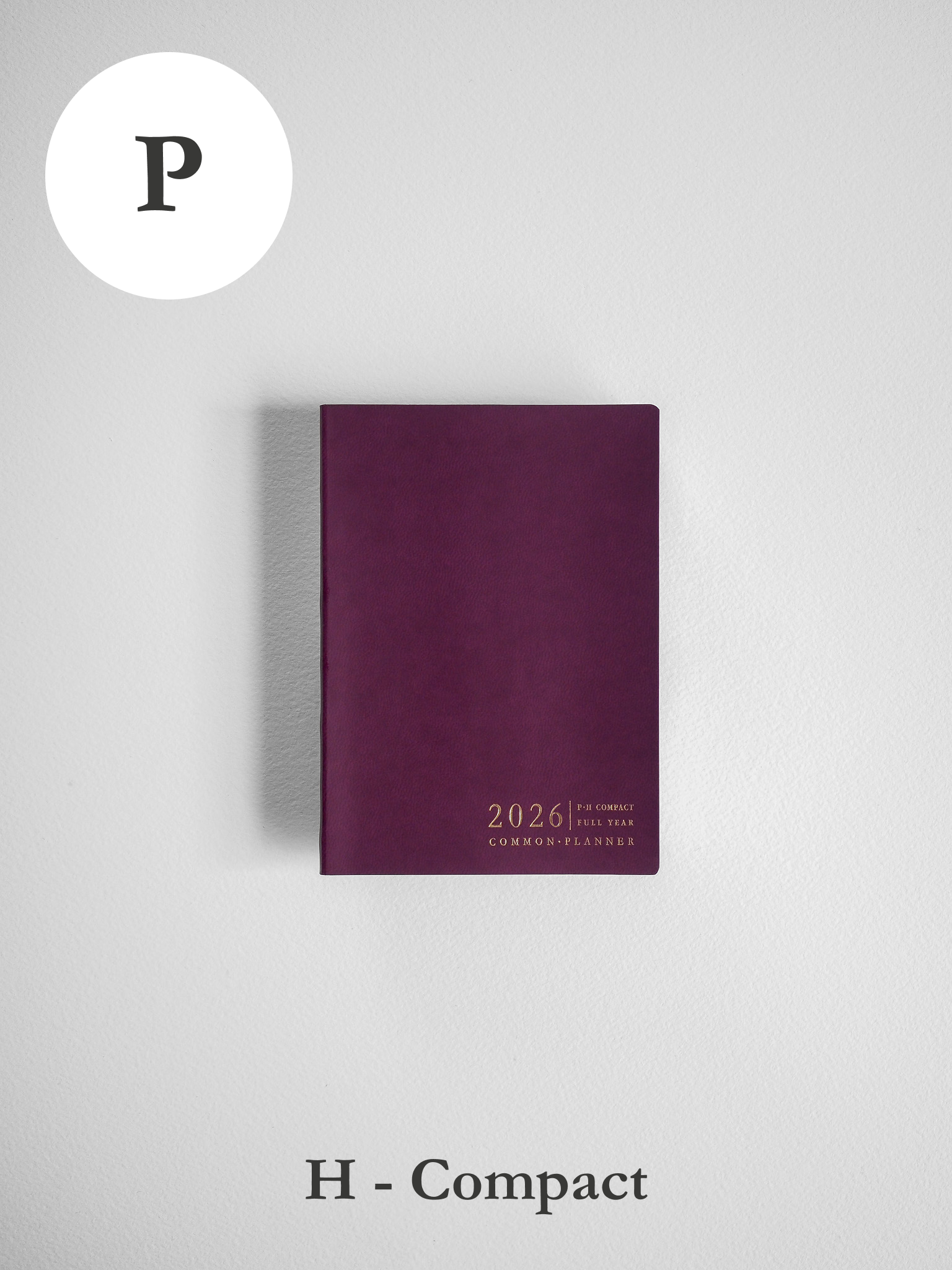 A compact, deep maroon planner featuring gold-embossed text that reads "2026 Common Planner" across its horizontal cover.