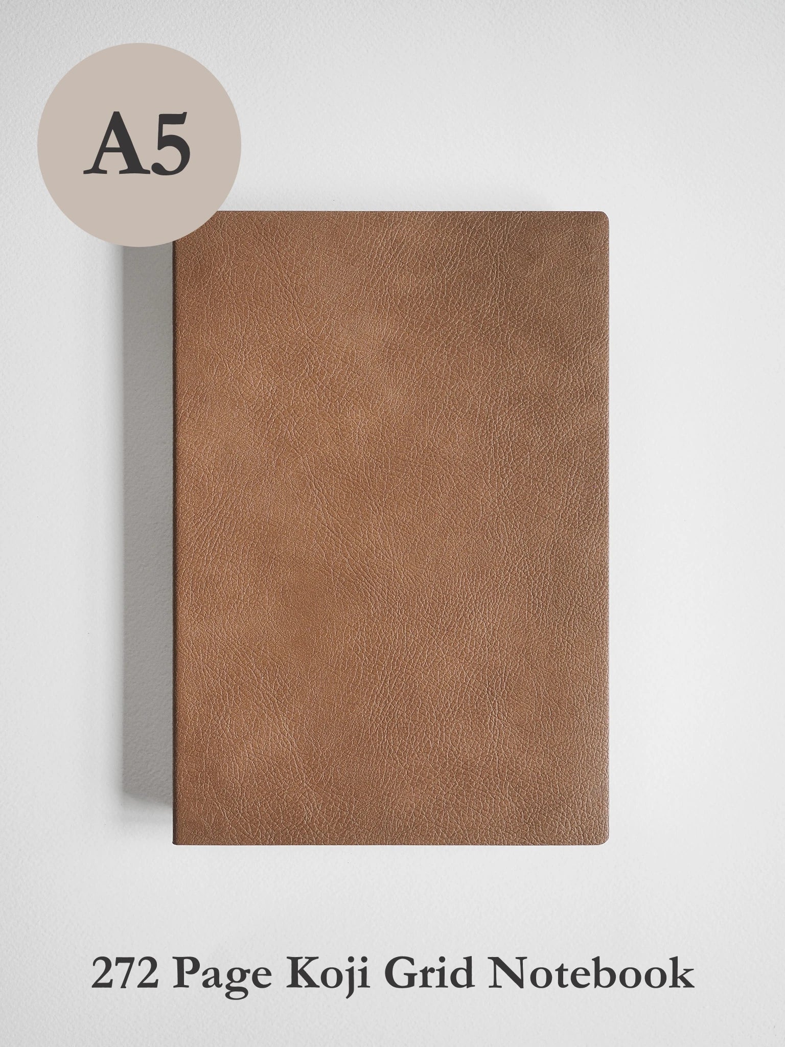 A brown textured notebook with a circular beige overlay reading 'A5' and text below reading '272 Page Koji Grid Notebook' on a light gray background.
#Color_Caramel