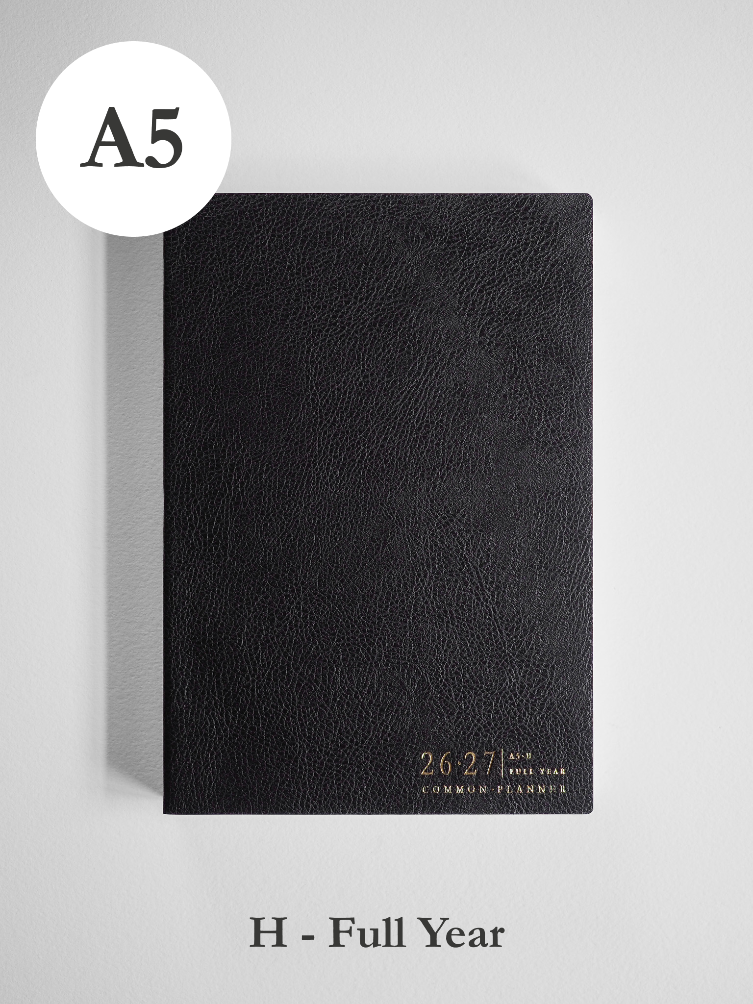 Black, textured A5 academic planner cover with prominent white embossed lettering displaying "26 27," offering a sophisticated and formal full-year design.