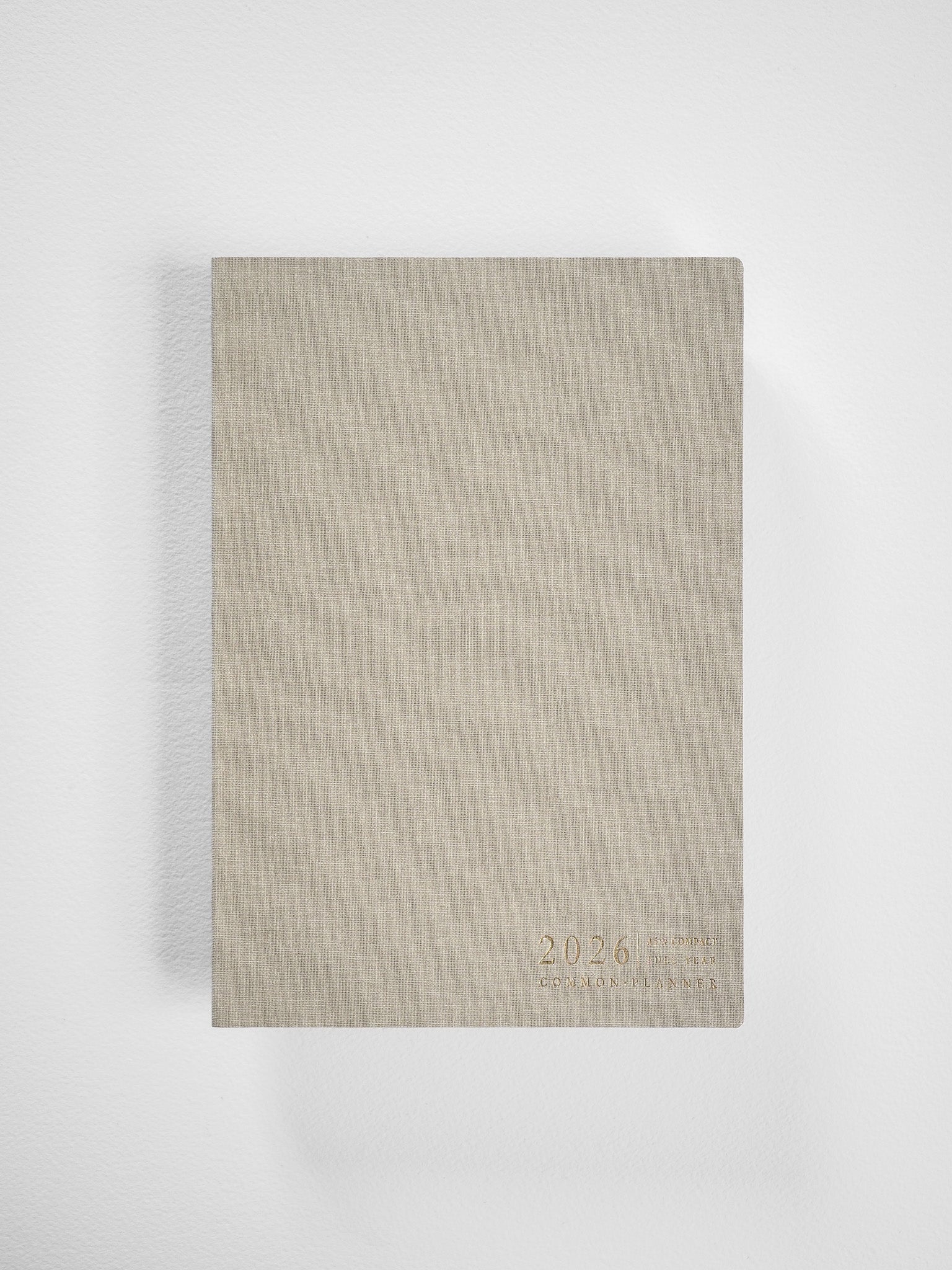 Minimalist A5 planner cover in light beige kraft paper featuring centered debossed text that reads "2026 Common Planner."
