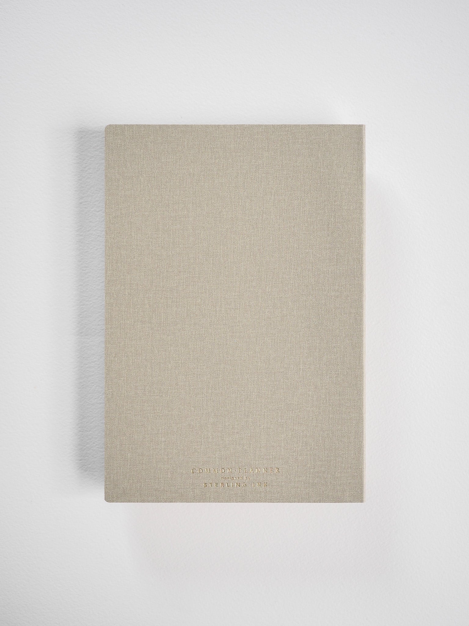 Neutral tan A5 planner featuring a linen-textured cover, displaying minimalist branding for Edmond Planner and Sterling Ink.