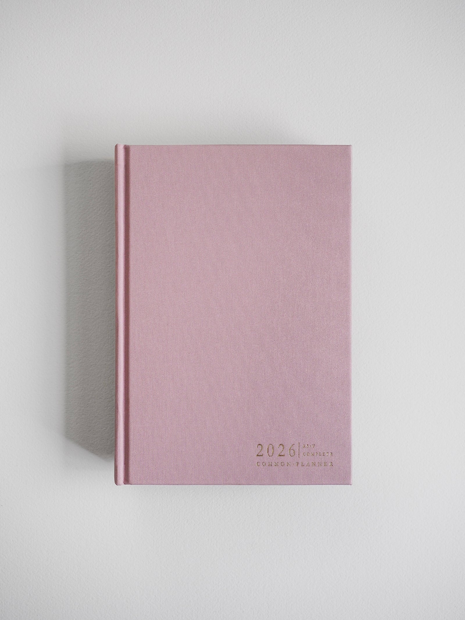 Minimalist A5 planner in a dusty rose hue, featuring the centered text "2026" and "Common Planner" for a subtle, elegant look.