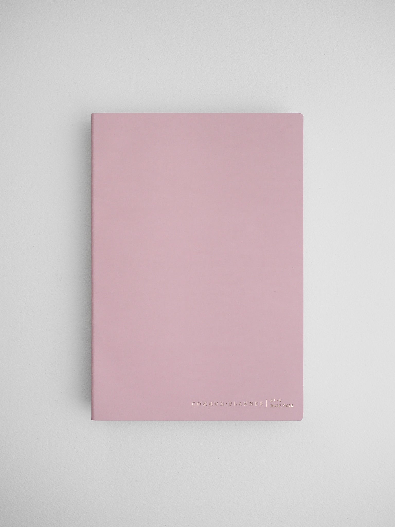 Minimalist light pink planner cover featuring a solid, soft blush hue and the branding "COMMON PLANNER | LIVE" at the bottom.