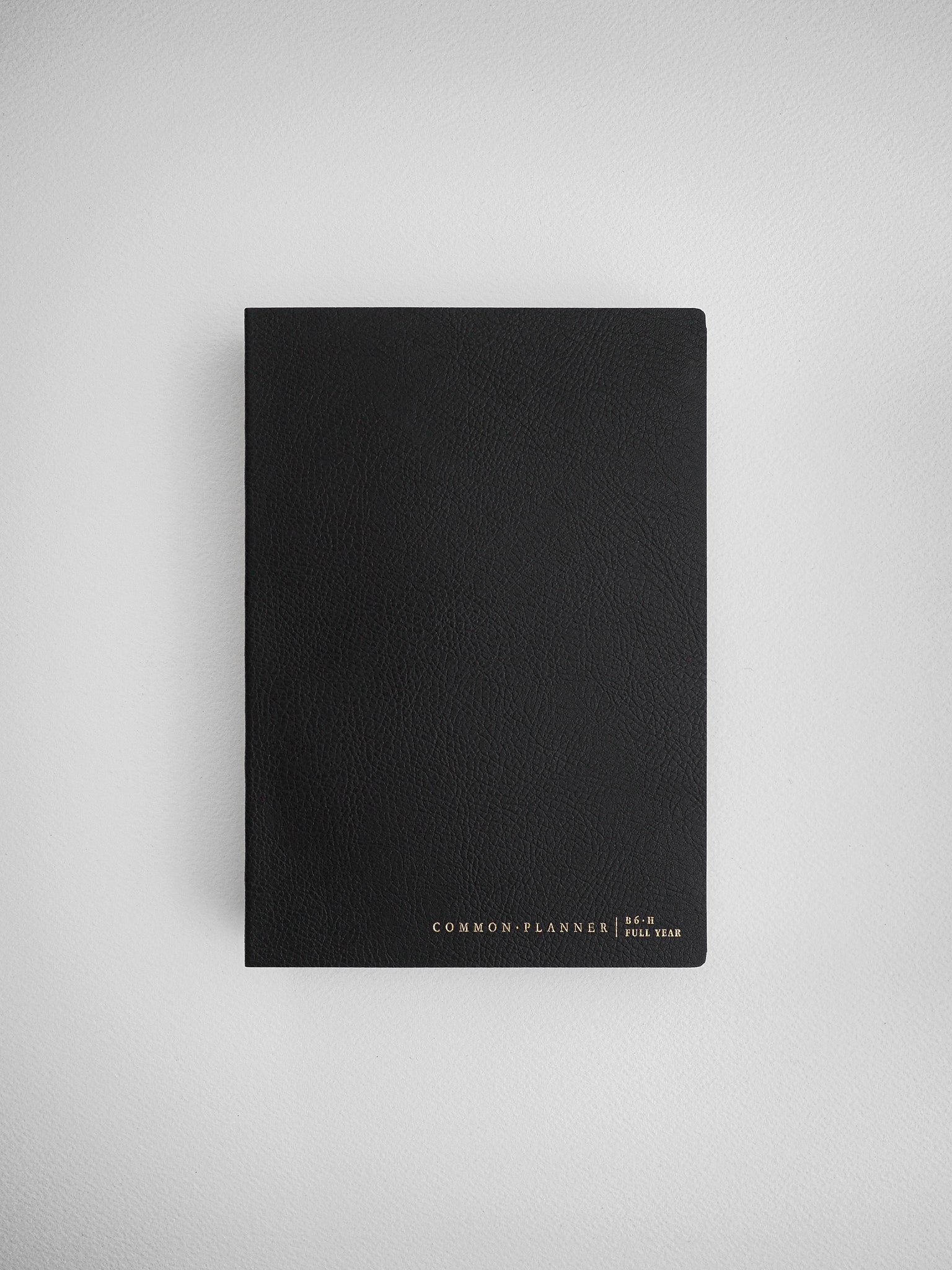 Sleek matte black planner cover that displays "Common Planner Full Year" text, perfect for minimalist undated journaling or scheduling.