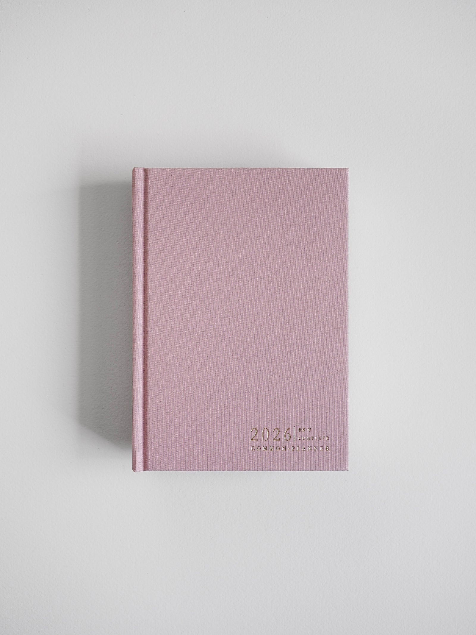 Dusty rose, vertical planner featuring the year 2026 and "Common Planner" in minimalist typography, ready for organization.