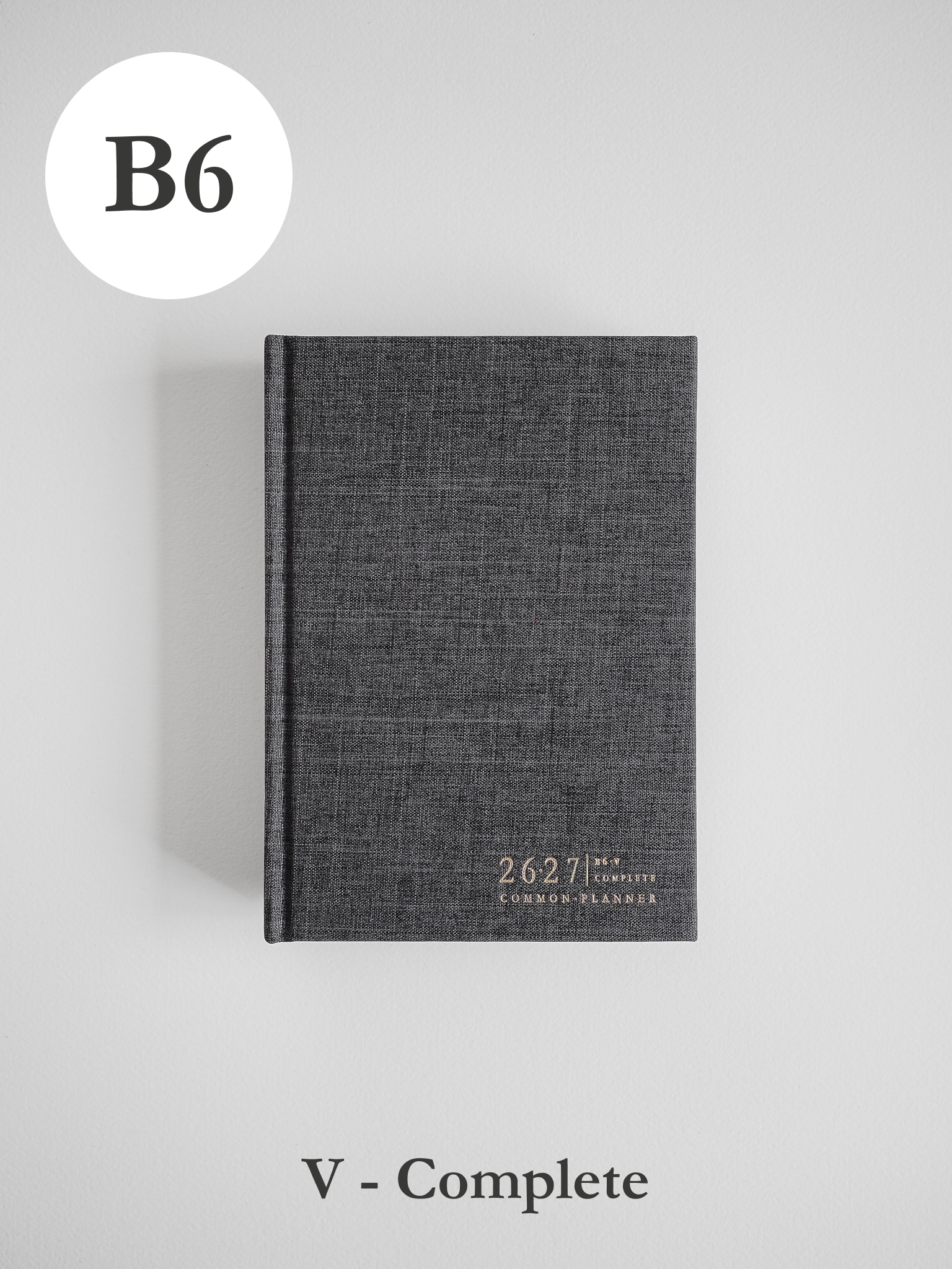 Elegant charcoal B6 planner featuring a textured cover and decorative metallic gold lettering that labels it as the Common Planner.