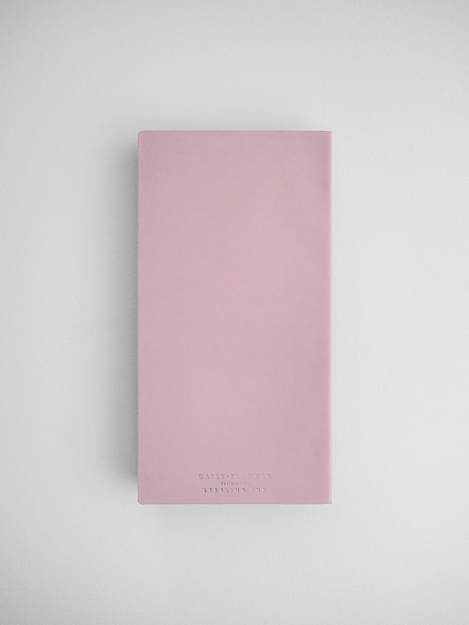 Blush pink daily planner with a clean, minimalist design, featuring "Daily Planner Sterling Linx" printed in a centered, elegant typeface.