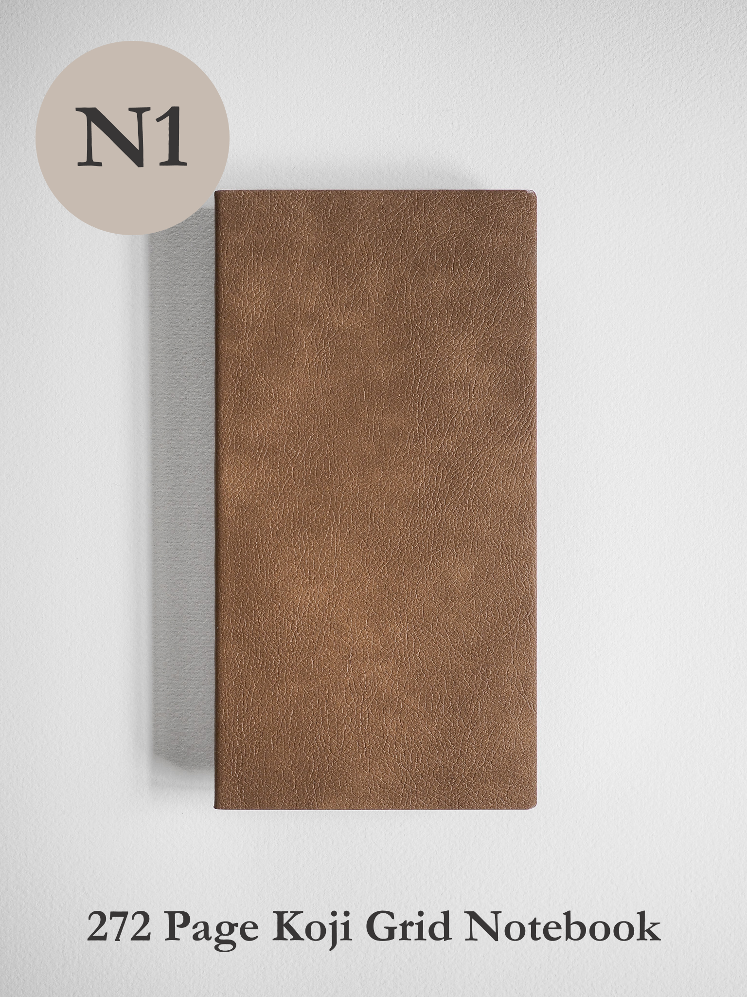 Medium-brown notebook featuring a solid, textured faux leather cover, containing 272 pages of gridded Koji paper for writing or drawing.