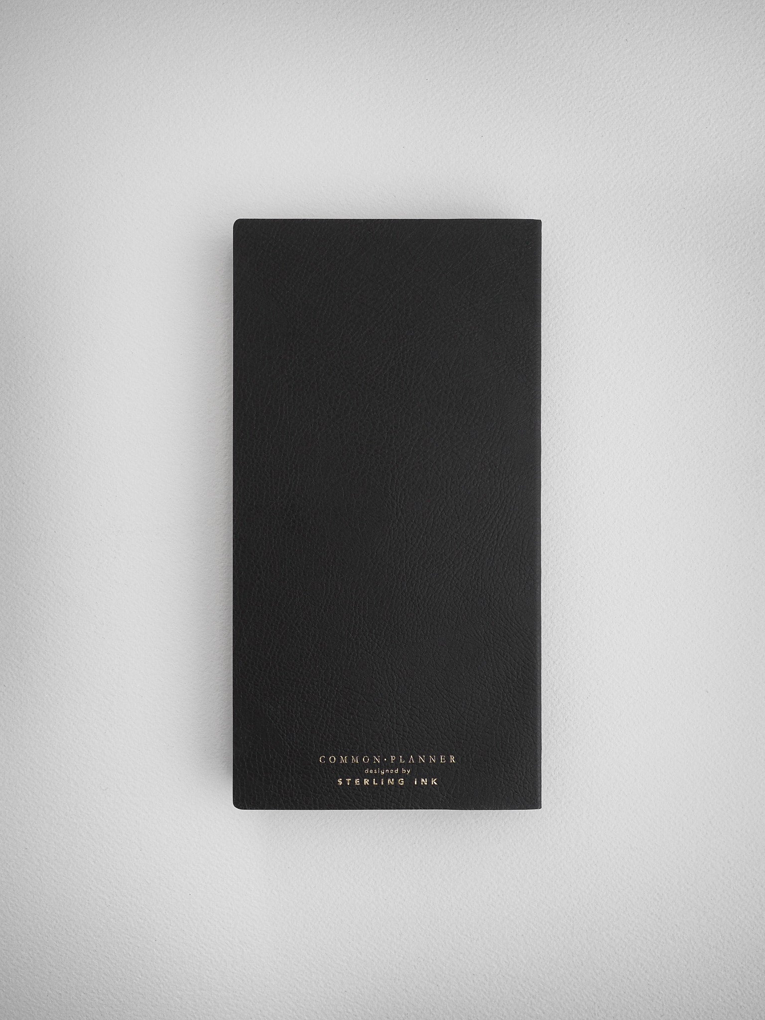 Sleek black common planner designed by Sterling Ink, featuring a minimalist cover for undated, horizontal journaling use.
