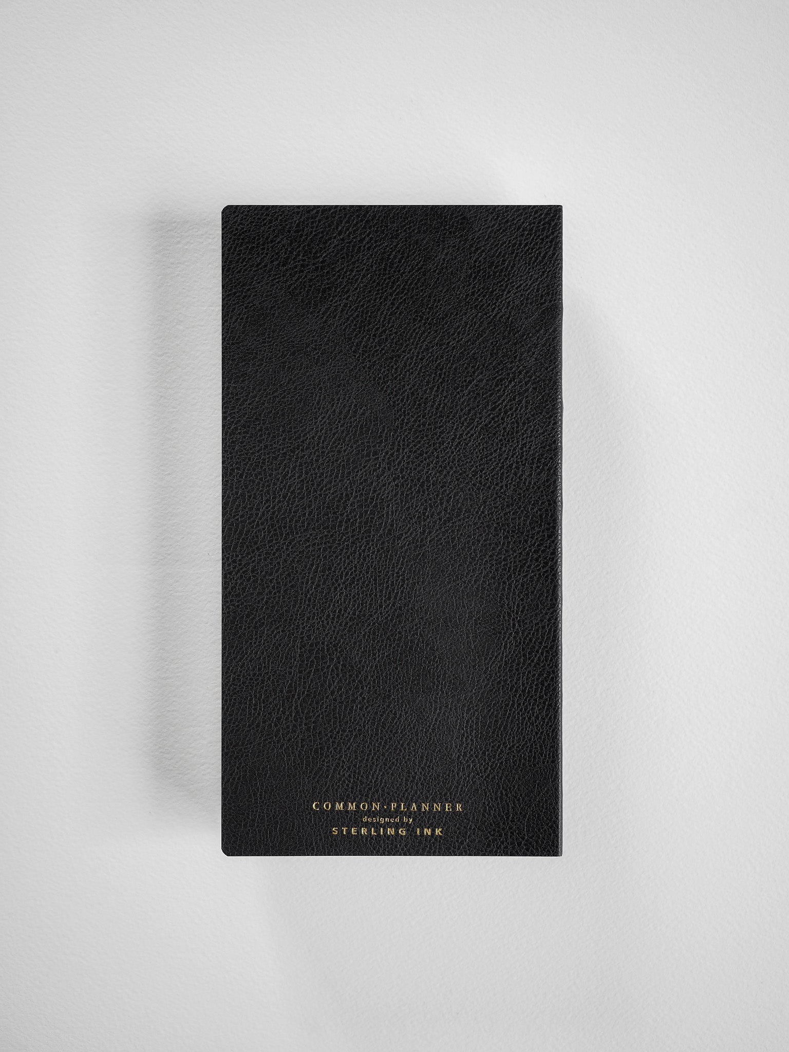 Textured black common planner featuring elegant gold foil typography displaying "COMMON PLANNER" and "STERLING INC" branding.