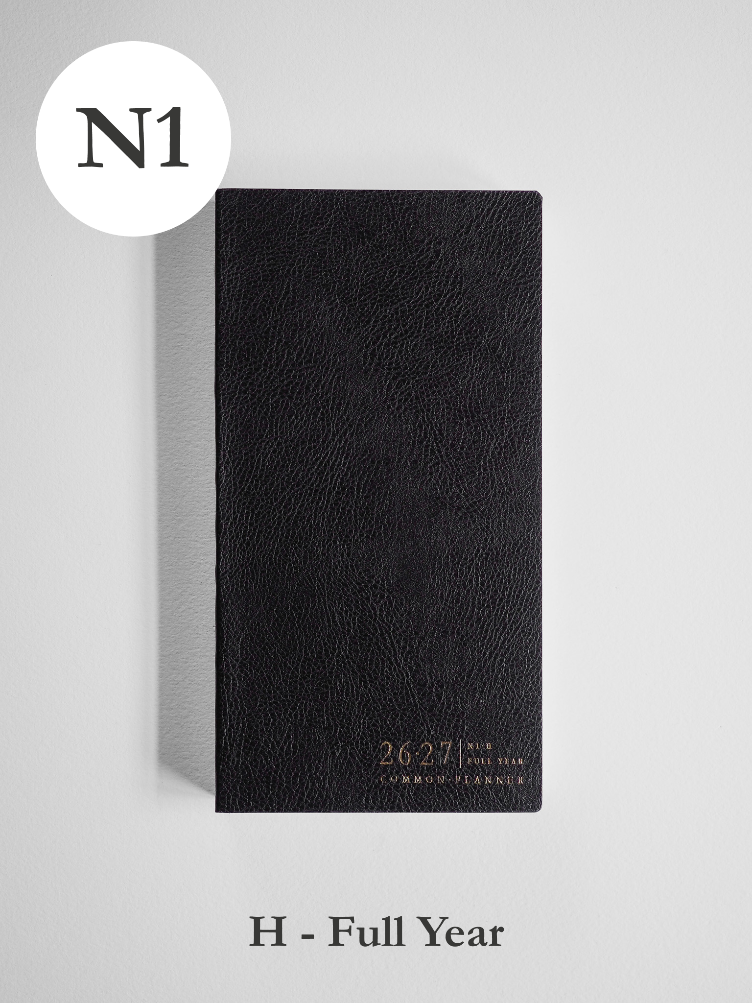 Black, textured faux-leather academic planner displaying "2026-2027" and "Common Planner" in stylish gold lettering.