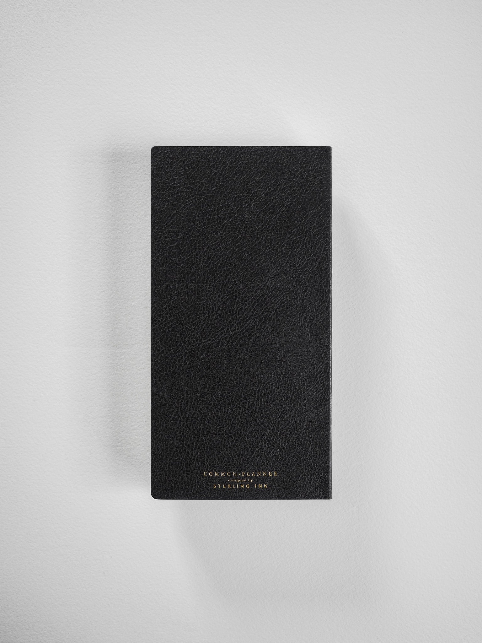 Luxurious, textured black planner cover featuring subtle gold branding and designed for comprehensive, full-year scheduling.
