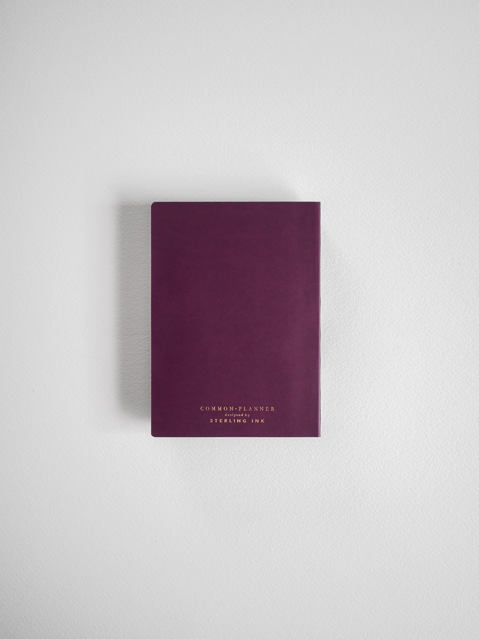 Compact, deep burgundy planner featuring elegant gold-toned branding for "Common Planner" and "Sterling Ink."