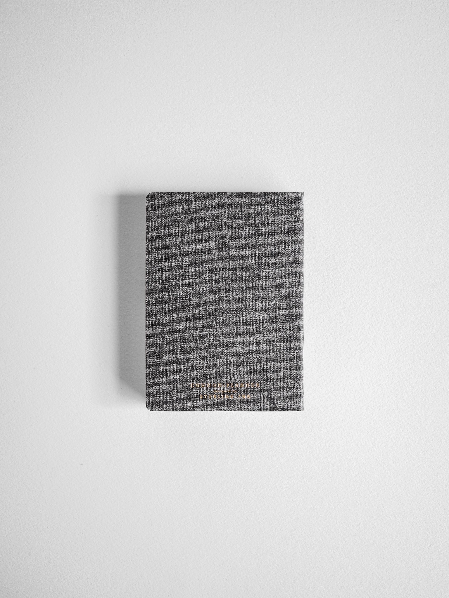 Textured gray compact planner with a horizontal design, featuring subtle centered gold lettering for a chic, unified aesthetic.