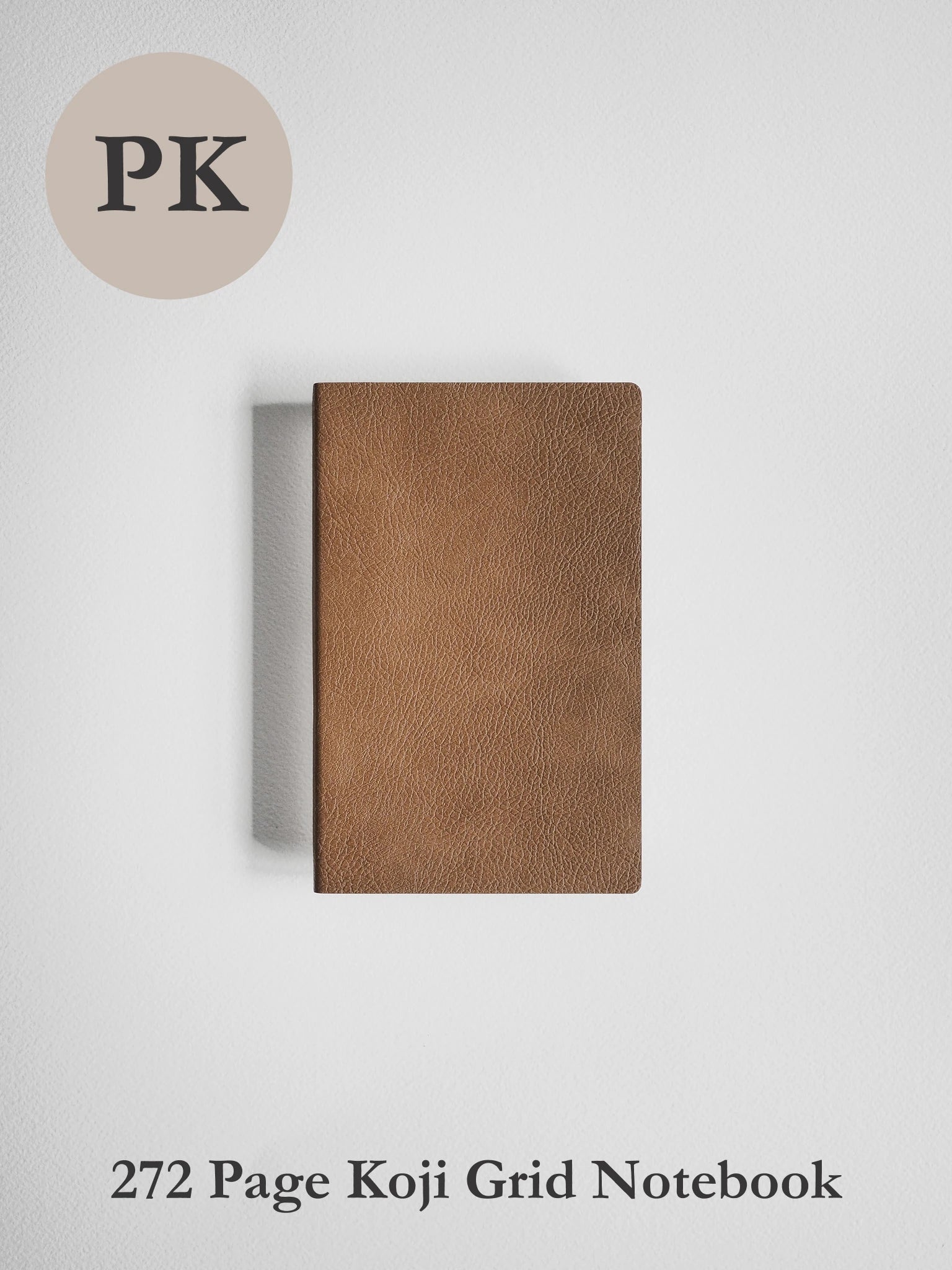 A brown textured notebook with a grid layout, shown closed on a light gray background. A beige circle in the top-left corner contains the text 'PK', and the text '272 Page Koji Grid Notebook' is printed at the bottom.
#Color_Caramel