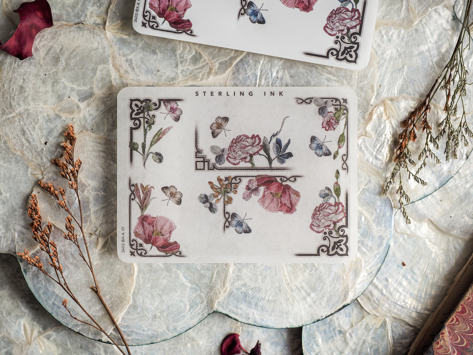 Vintage decorative sticker sheets featuring a delicate botanical pattern of blush roses, deep red florals, blue butterflies, and intricate corner borders.