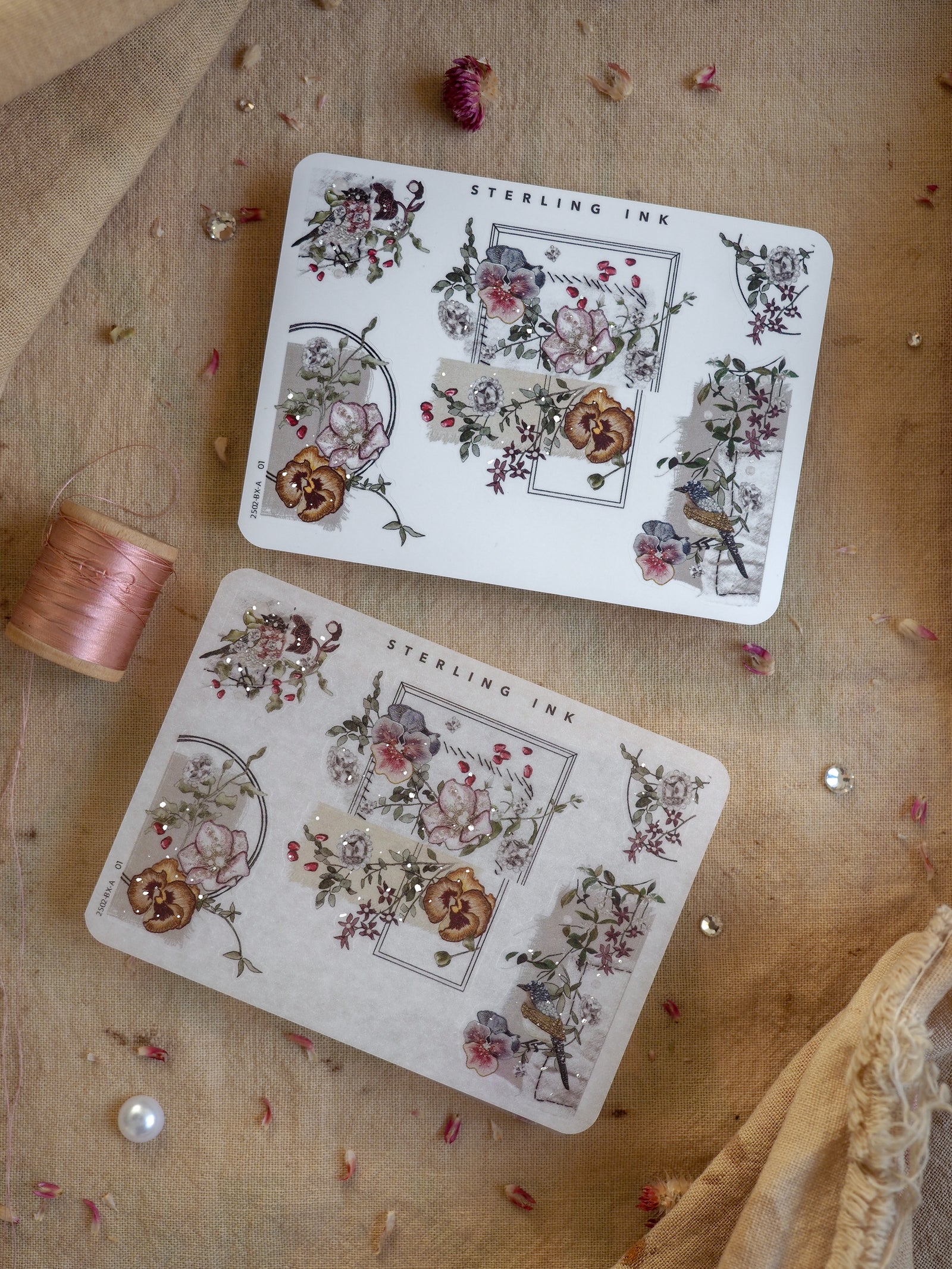 Delicate sheets of vintage floral stickers featuring rose clusters, decorative corners, and intricate border designs with subtle silver foil accents, titled "Sterling Ink."