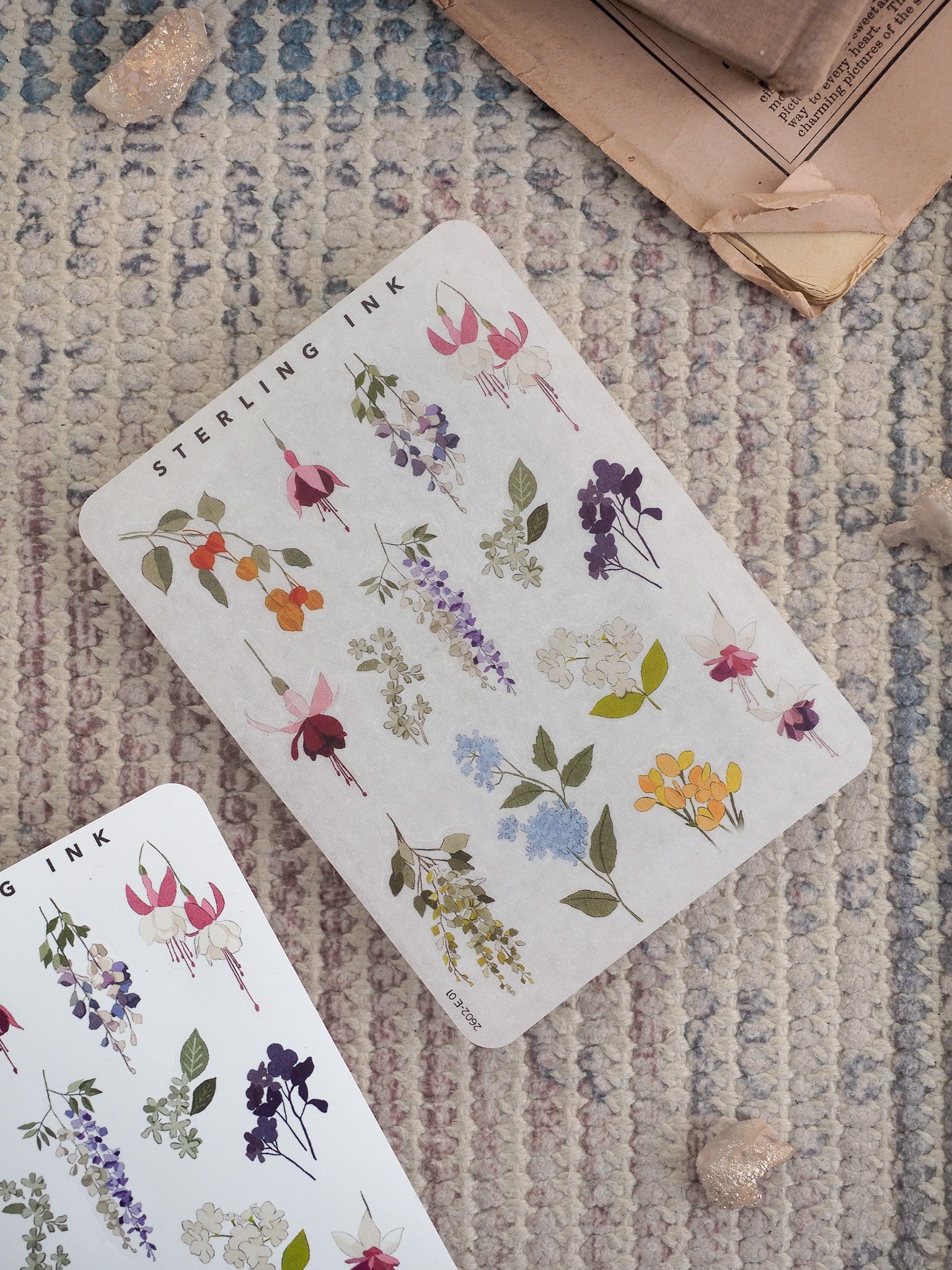 A beautiful sticker sheet featuring watercolor botanical elements of vibrant pink, purple, and yellow meadow flowers and detailed green foliage.