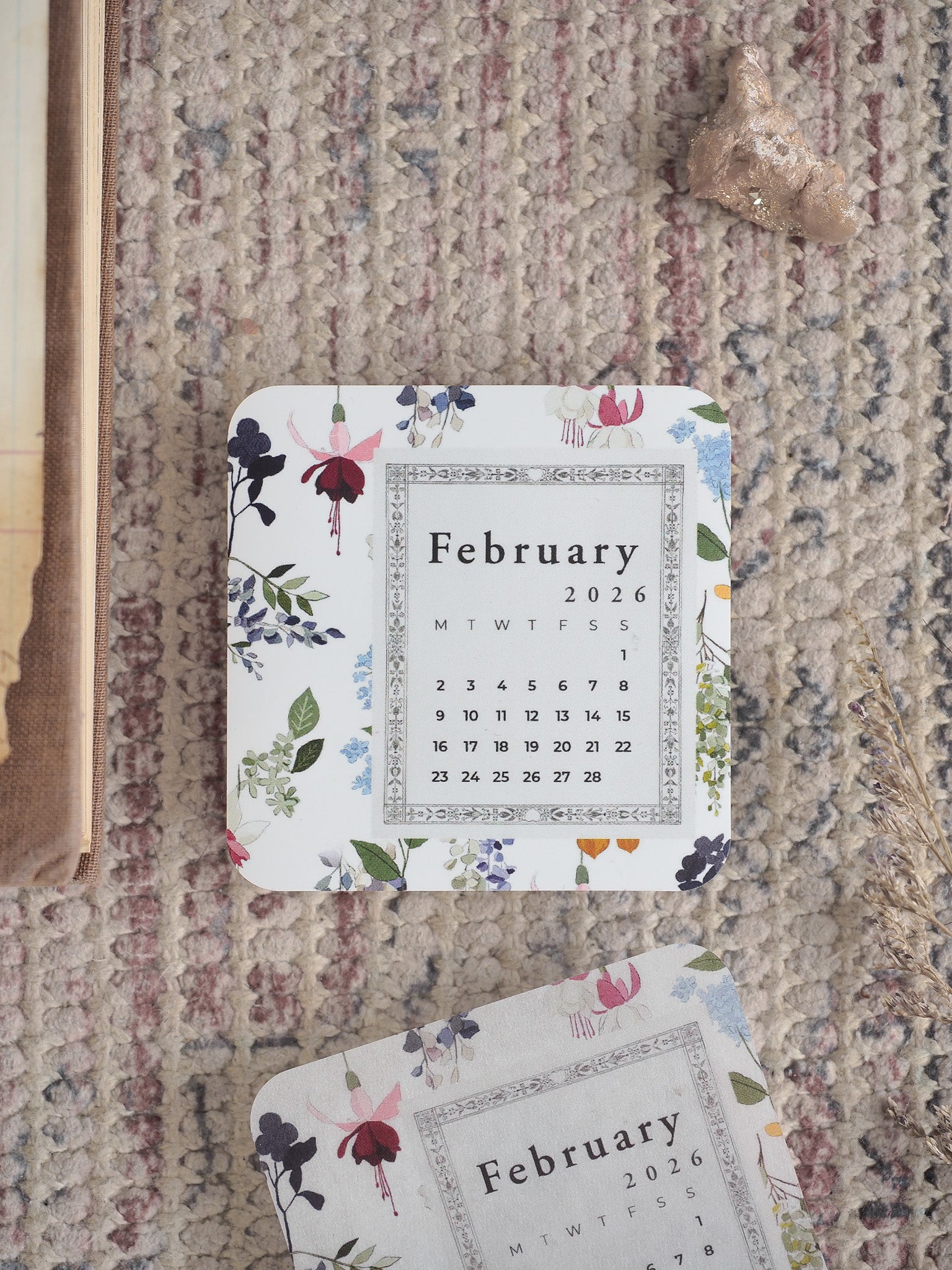 Elegant printable calendar page for February 2026, adorned with delicate watercolor floral bouquets featuring blush pink, deep blue, and sage green accents.