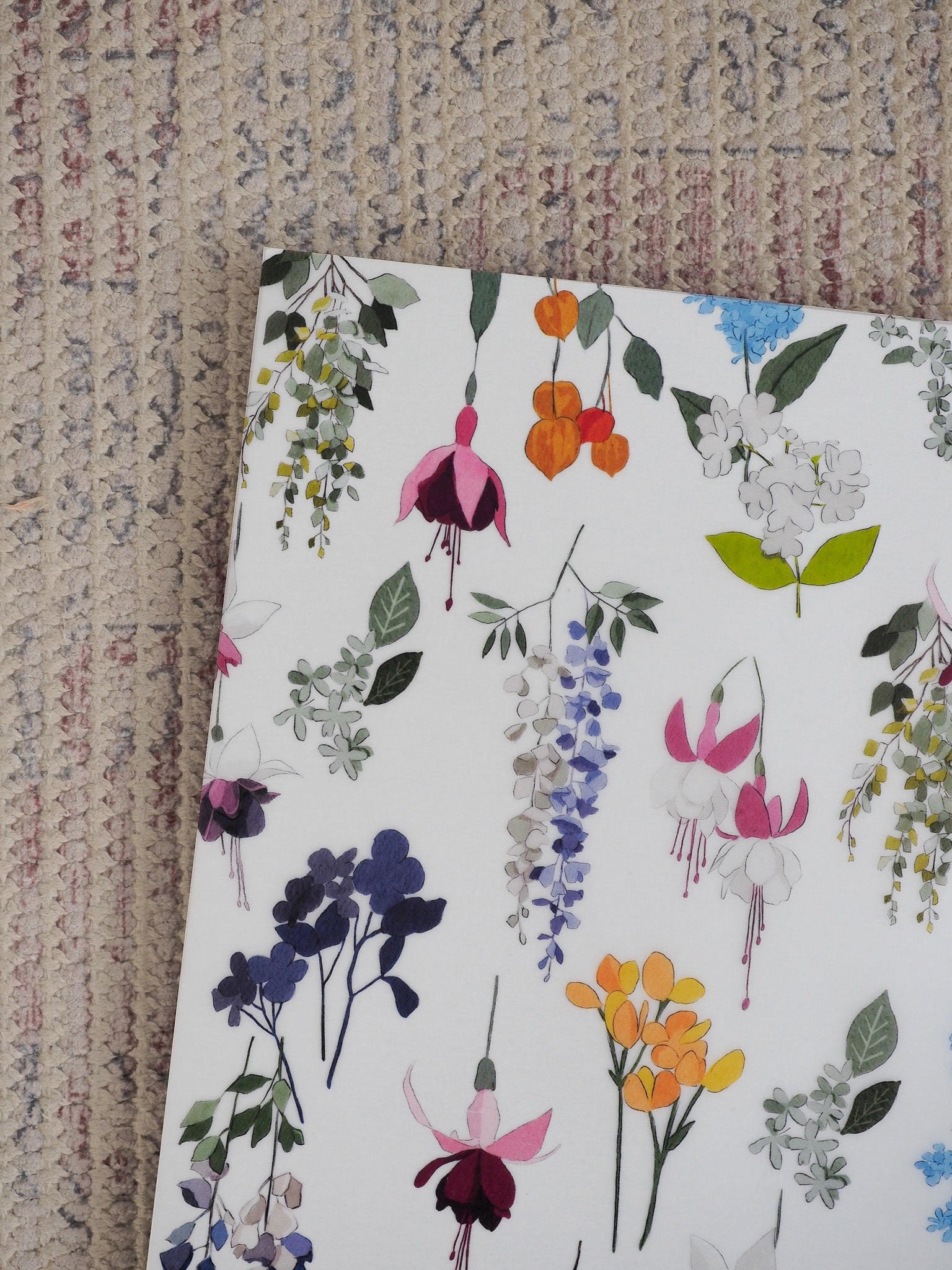 Watercolor botanical cover featuring a dense, colorful pattern of hanging spring flowers in vibrant shades of purple, pink, yellow, and orange.