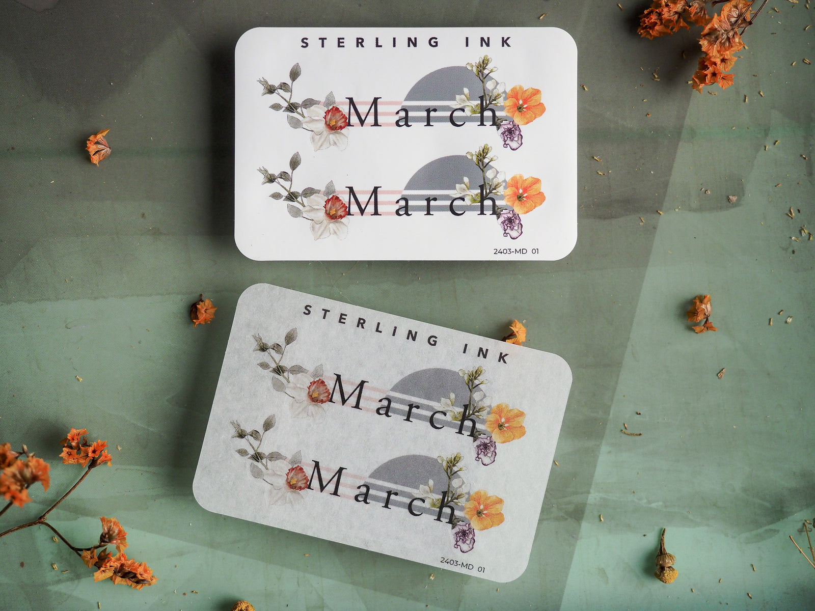 White "March" month sticker featuring delicate watercolor bouquets of pink, yellow, and purple blossoms and leaves, perfect for seasonal journaling and scrapbooking.