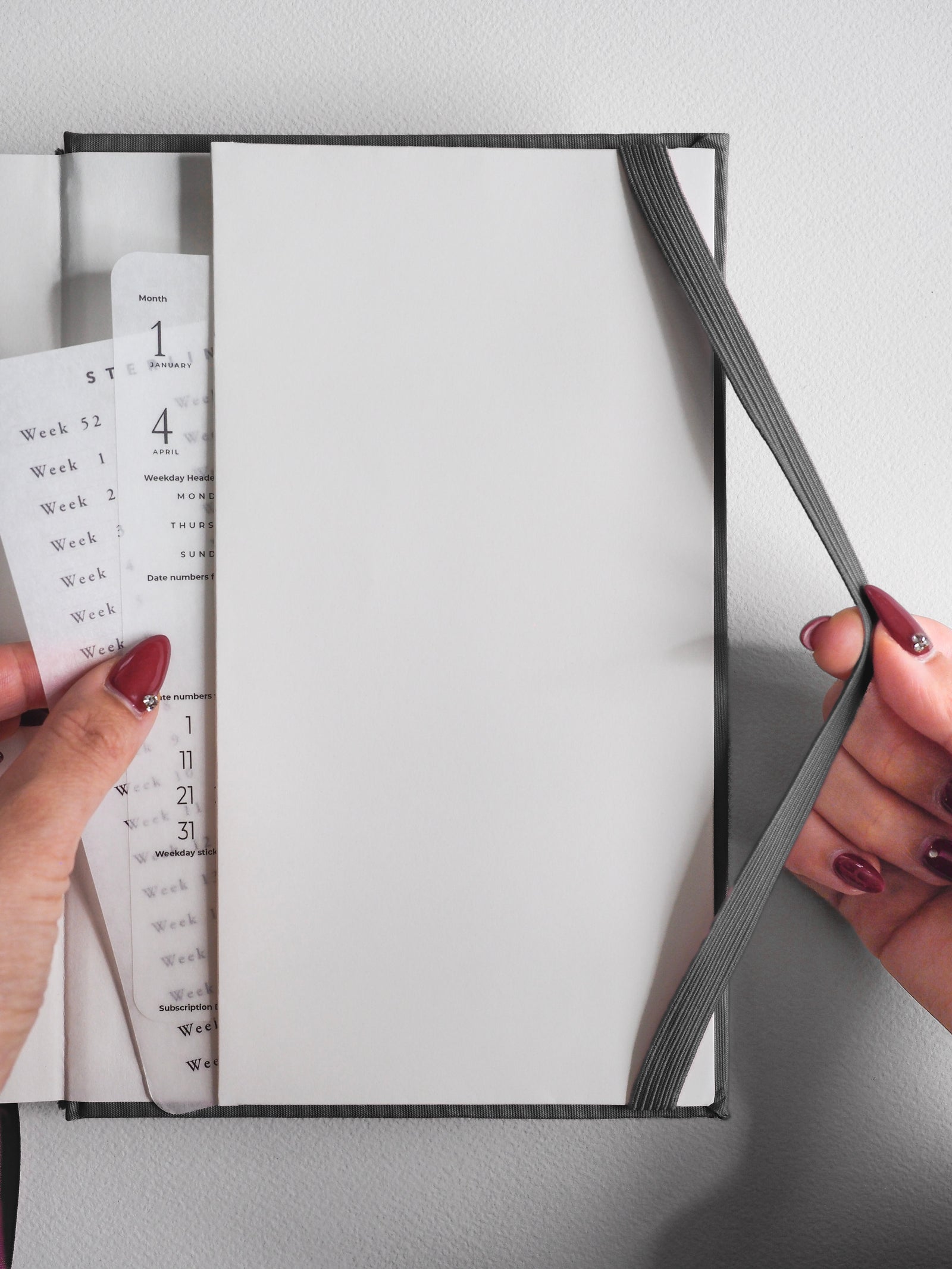 A sophisticated A5 vertical 2026 planner with a neutral gray cover, featuring comprehensive printed weekly and monthly grids for detailed year-long scheduling.