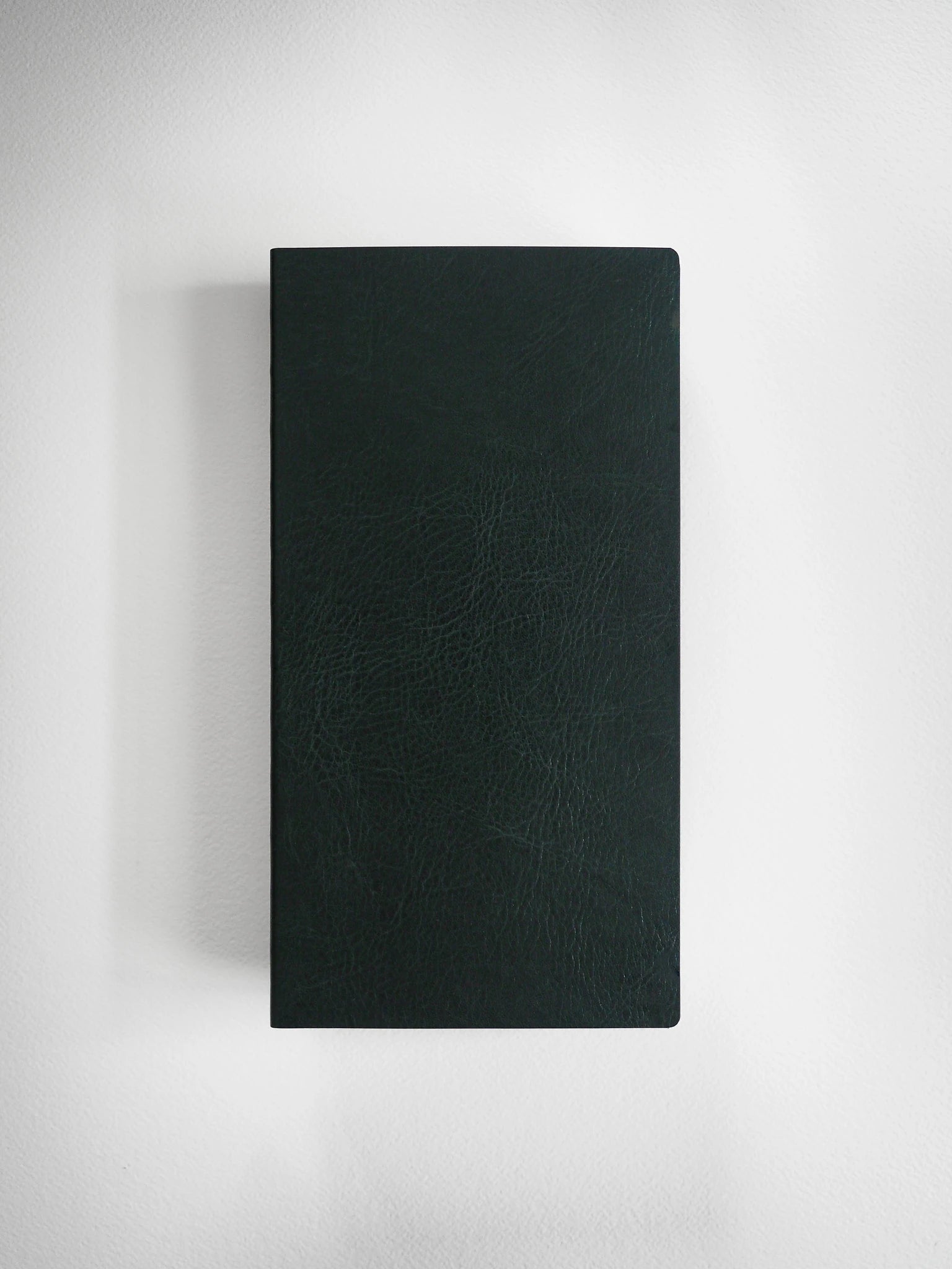 A dark green textured leather notebook or journal with a black spine, shown vertically against a light gray background.
#Color_Forest