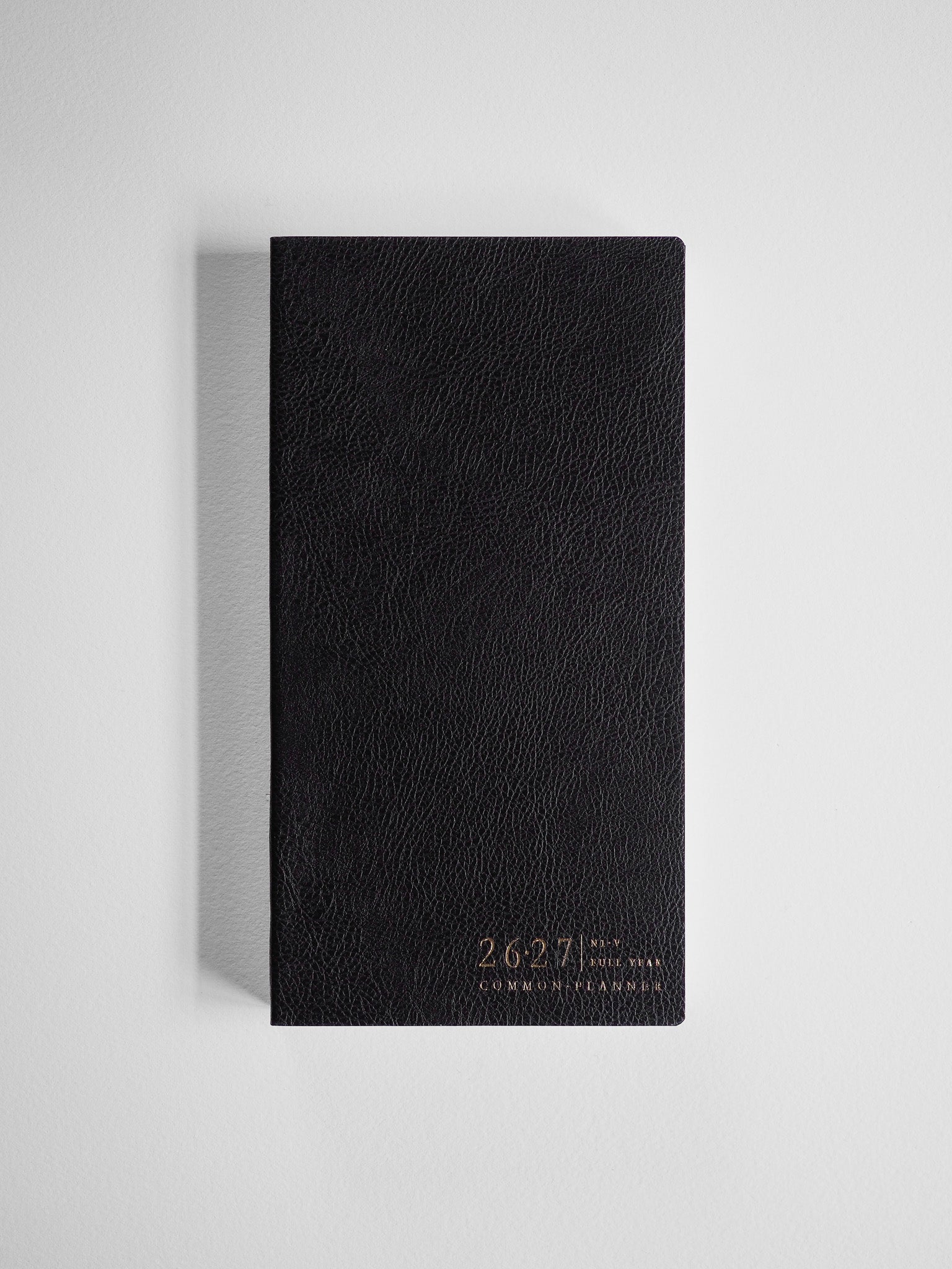 Textured black academic planner for the 2026-2027 school year, featuring elegant embossed gold lettering identifying it as the Common Planner.