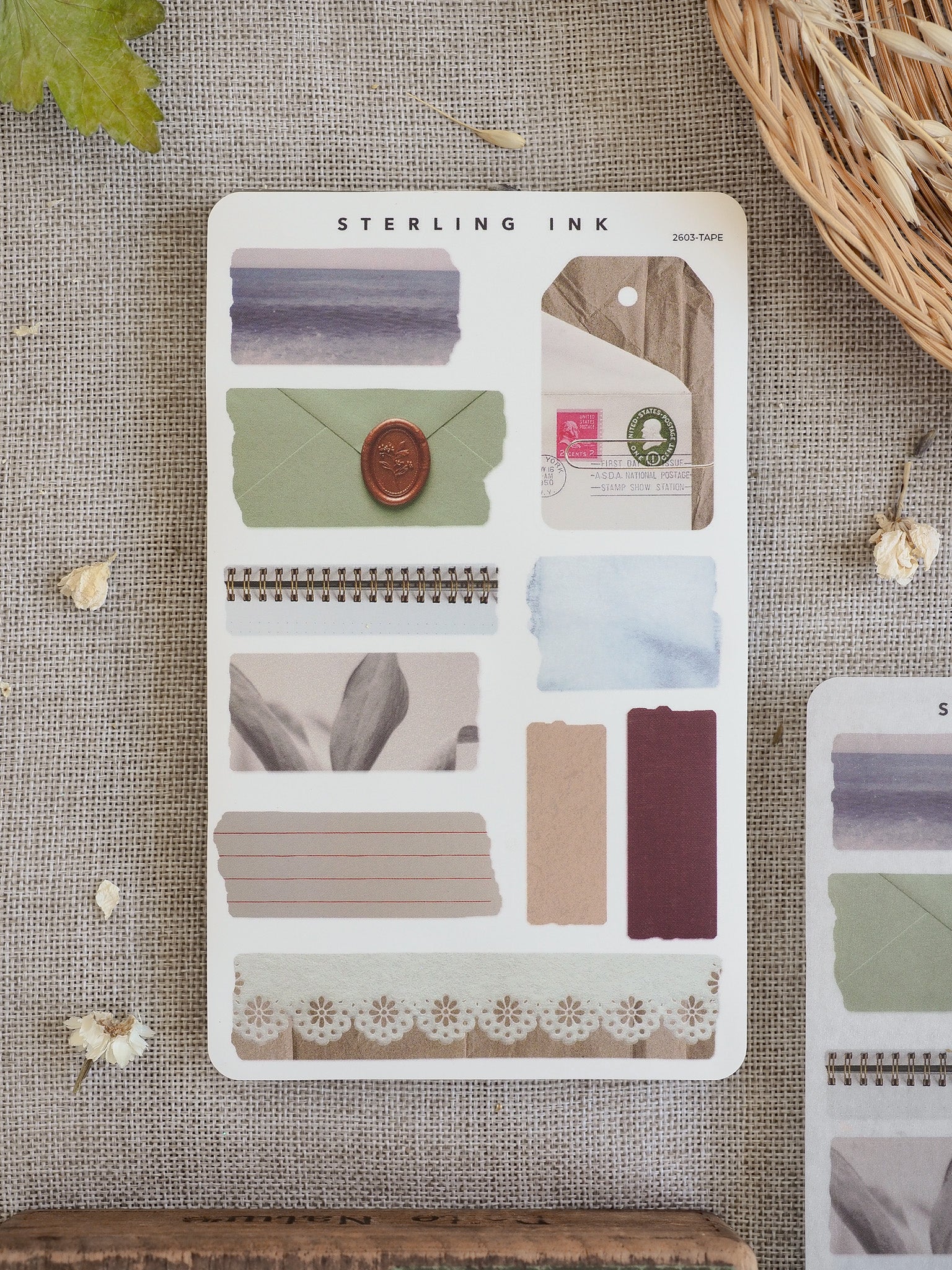 Various torn tape stickers in dusty blue, beige, and cream tones, including solid strips and delicate patterned washi designs for journal scrapbooking.