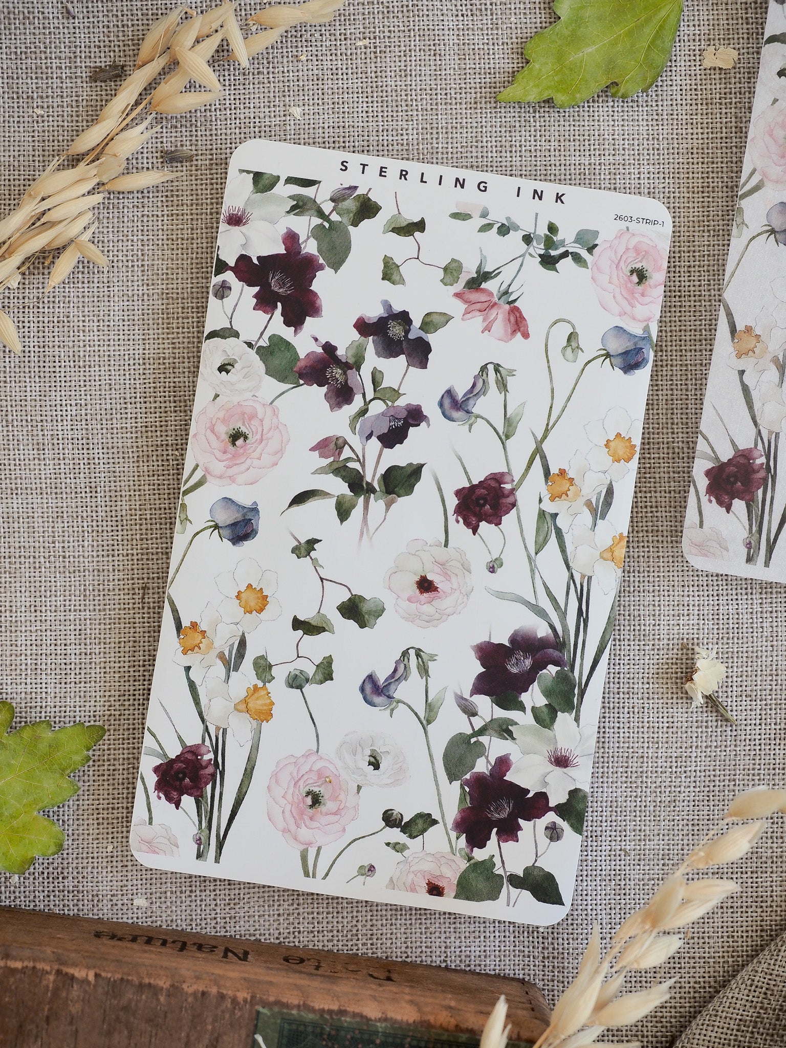 Delicate floral sticker strip featuring detailed watercolor clusters of deep purple, blush pink, and white peonies and surrounding green foliage.