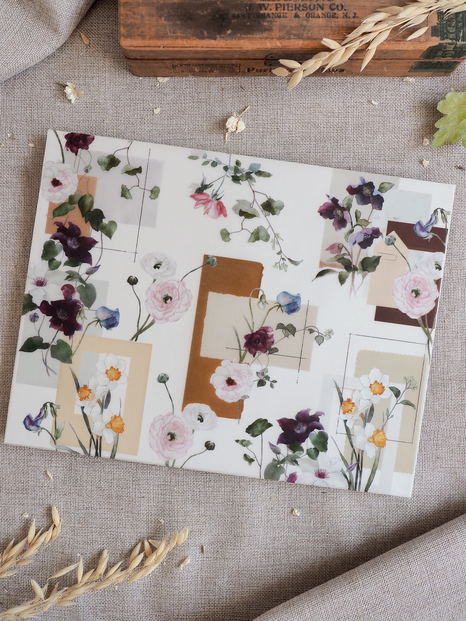 Watercolor floral pattern featuring soft blush, lilac, and cream blooms set against a modern, structured grid of neutral tan and ivory geometric blocks.
