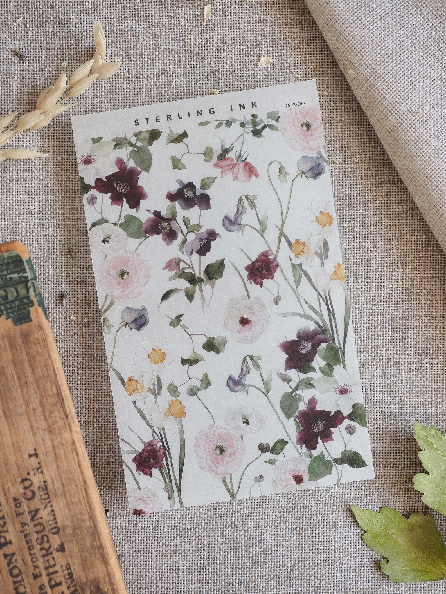 A charming floral deco sheet featuring a watercolor pattern of muted blush pink, dusty purple, and deep burgundy blossoms for crafting.