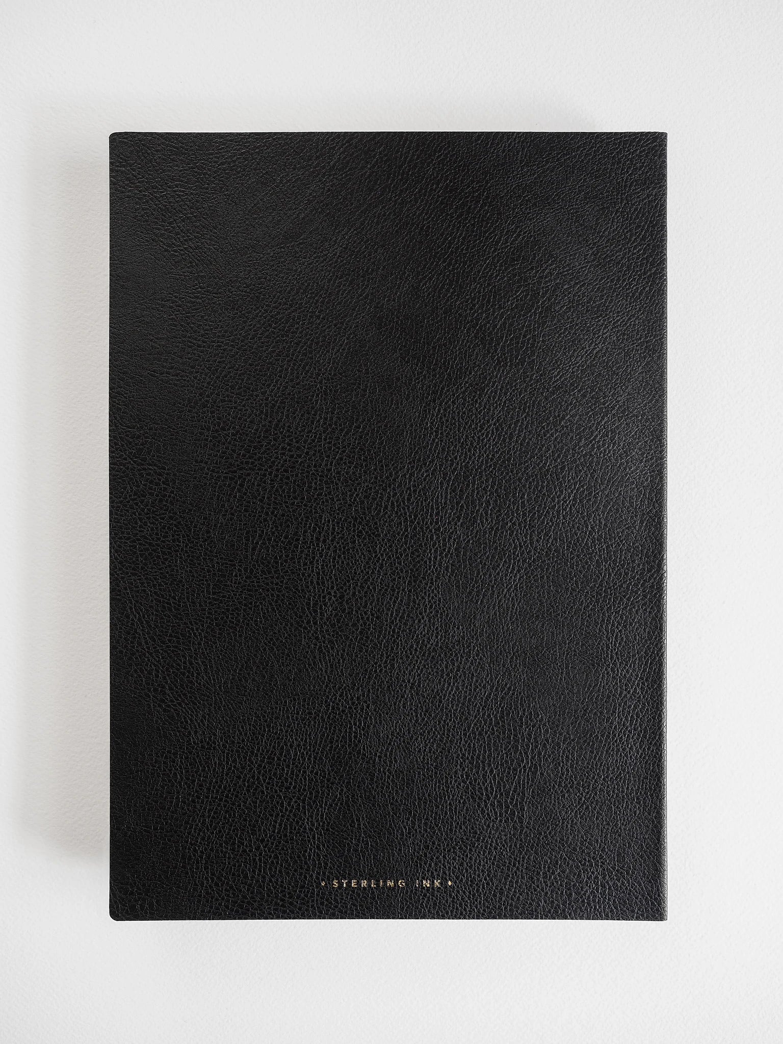 A black textured notebook or journal with a minimalist design, featuring the brand name 'STERLING INK' in small gold lettering at the bottom center, displayed on a clean white background.
#Color_Onyx