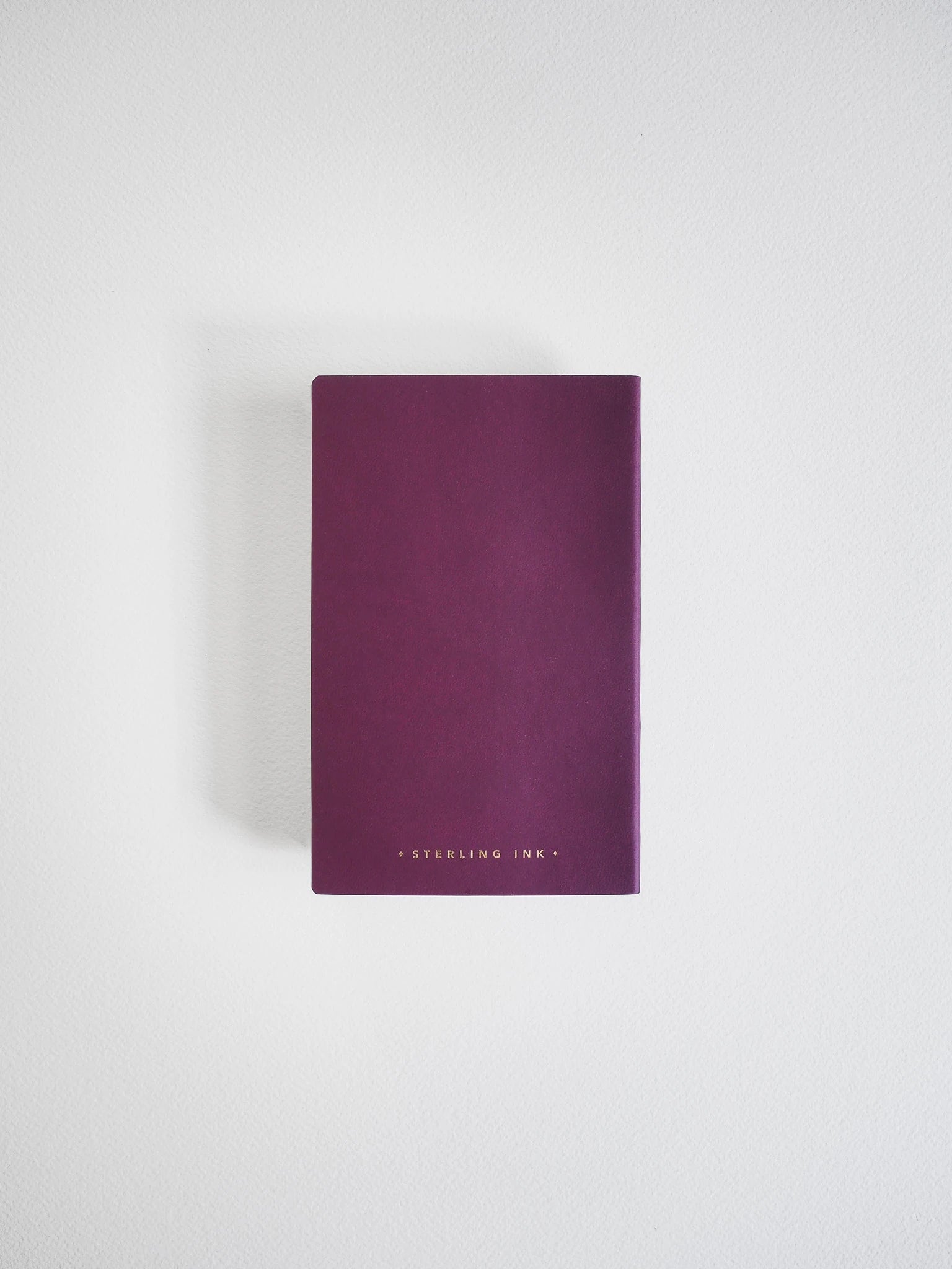A dark purple hardcover notebook or journal with 'STERLING INK' printed in small gold letters at the bottom, centered on a light gray background.
#Color_Mulberry