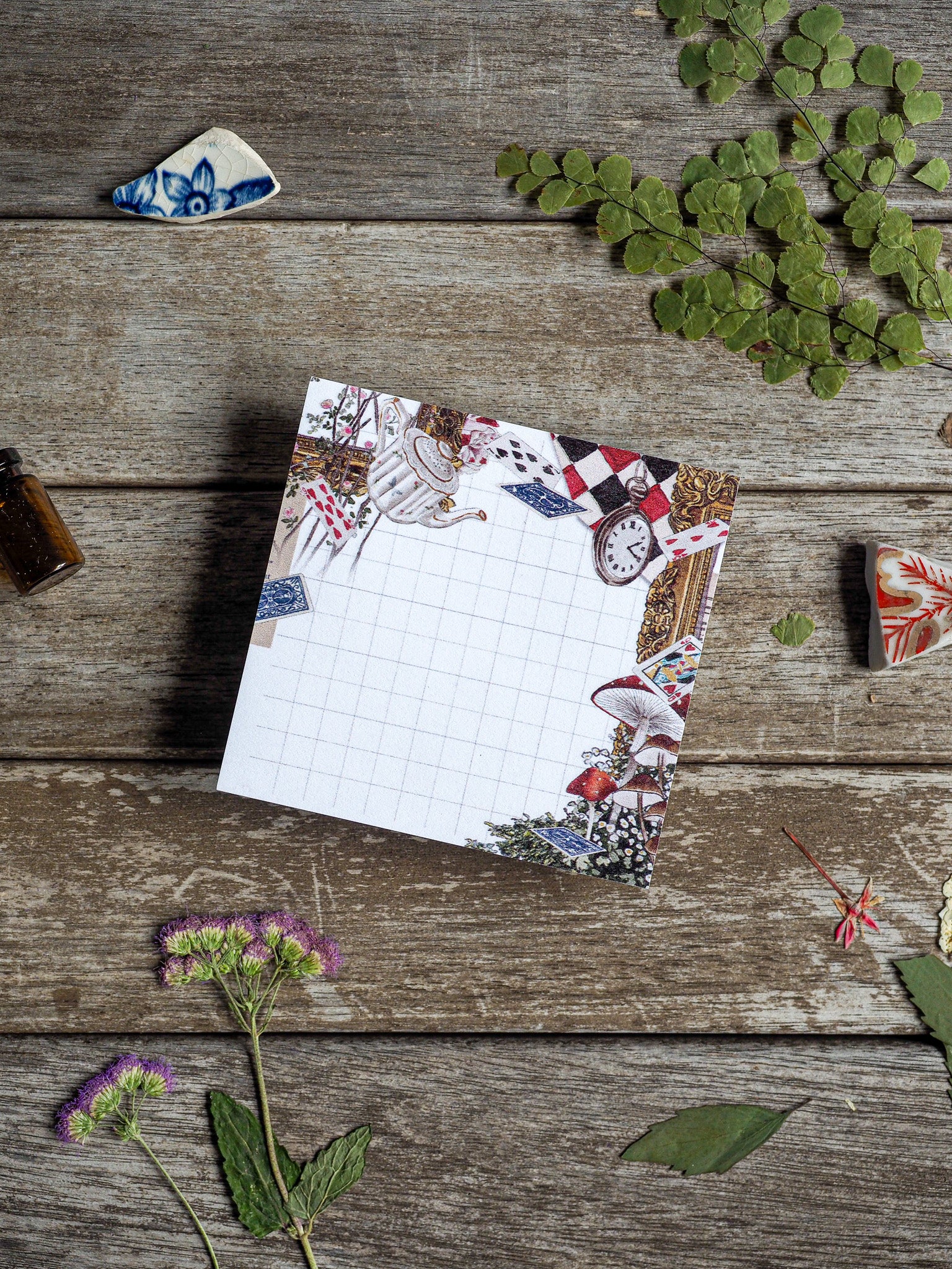 A square, gridded sticky note framed with a festive collage border featuring vintage teacups, clocks, and spring floral patterns for April planning.
