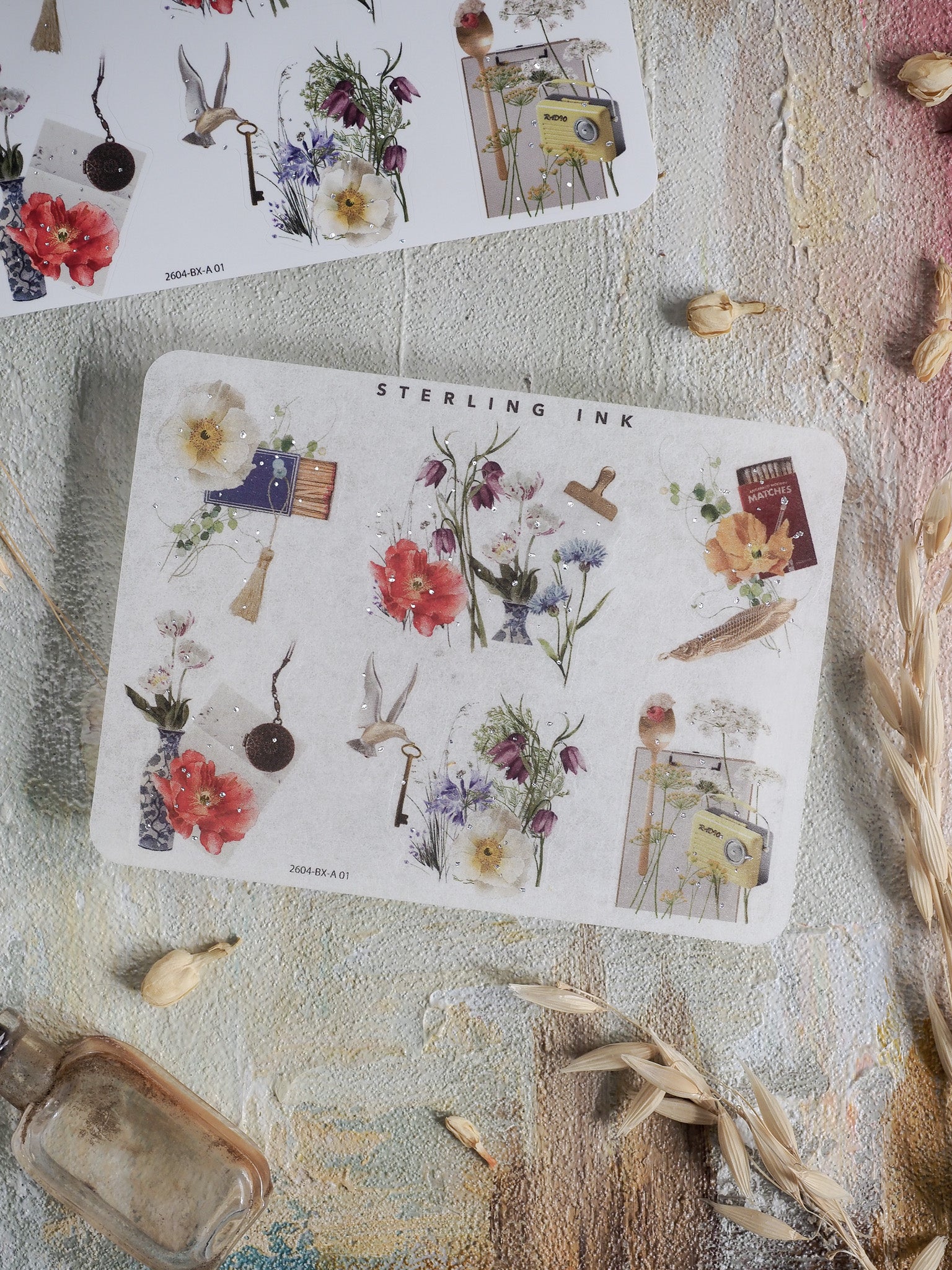 Detailed sticker sheet featuring antique botanical corner stickers with silver foil accents, highlighting vibrant florals, herbs, and vintage stationery motifs.