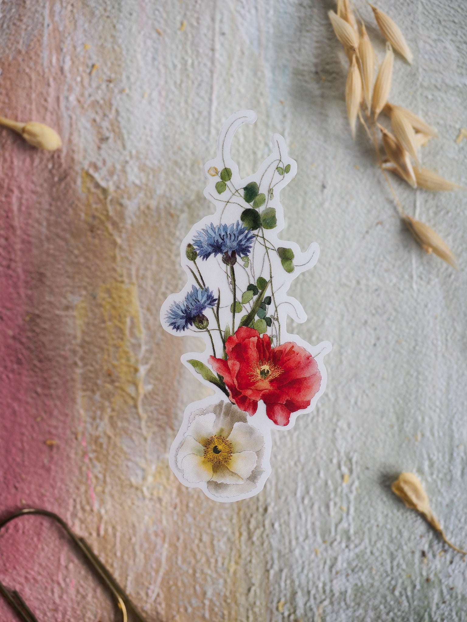Vibrant die-cut sticker featuring watercolor botanical illustrations of diverse spring florals, including bold red blooms, soft blue clusters, and delicate cream blossoms.