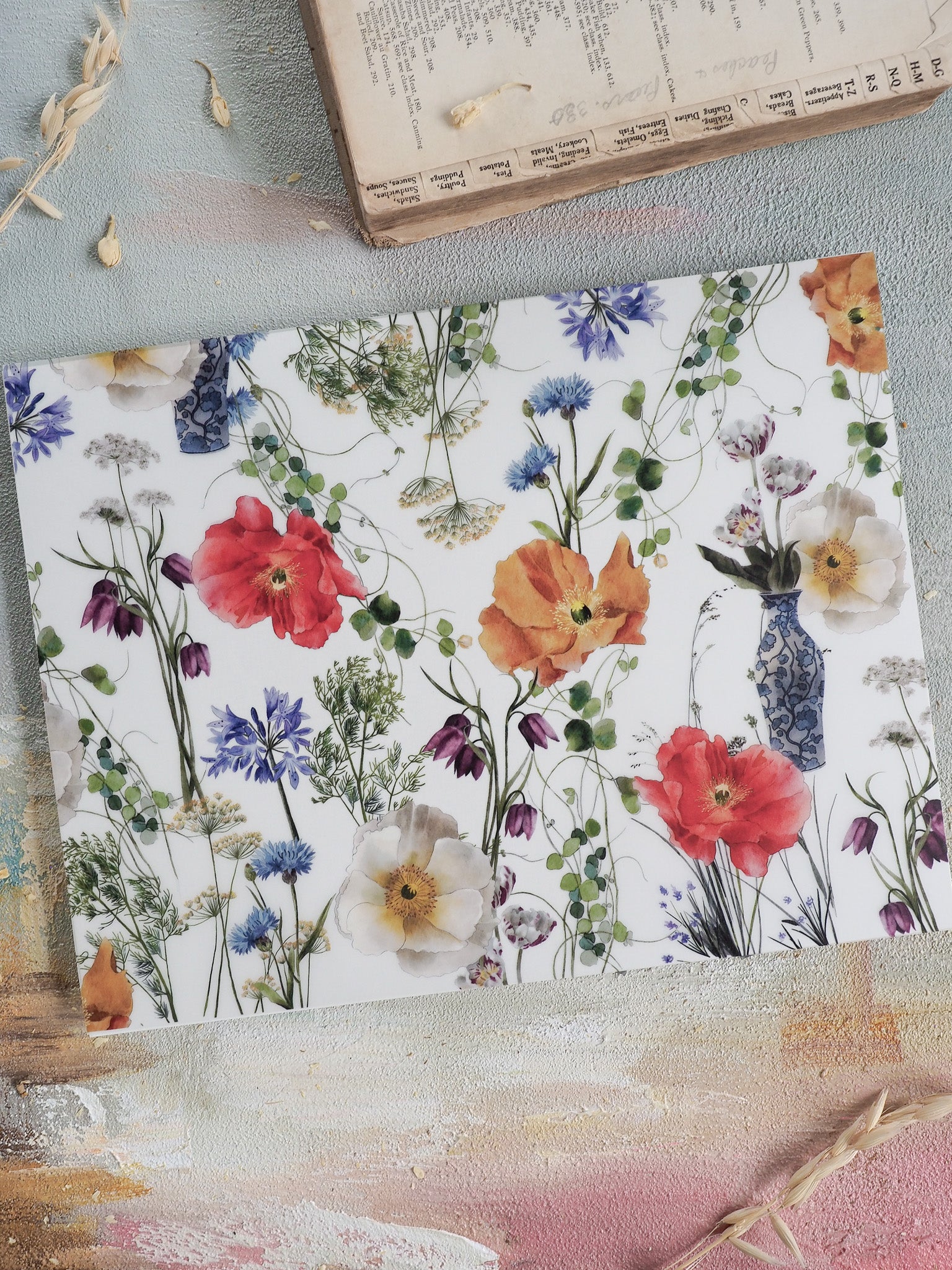 Elegant watercolor floral pattern featuring vibrant red poppies, soft yellow blooms, and clusters of deep blue flowers on a clean white background.