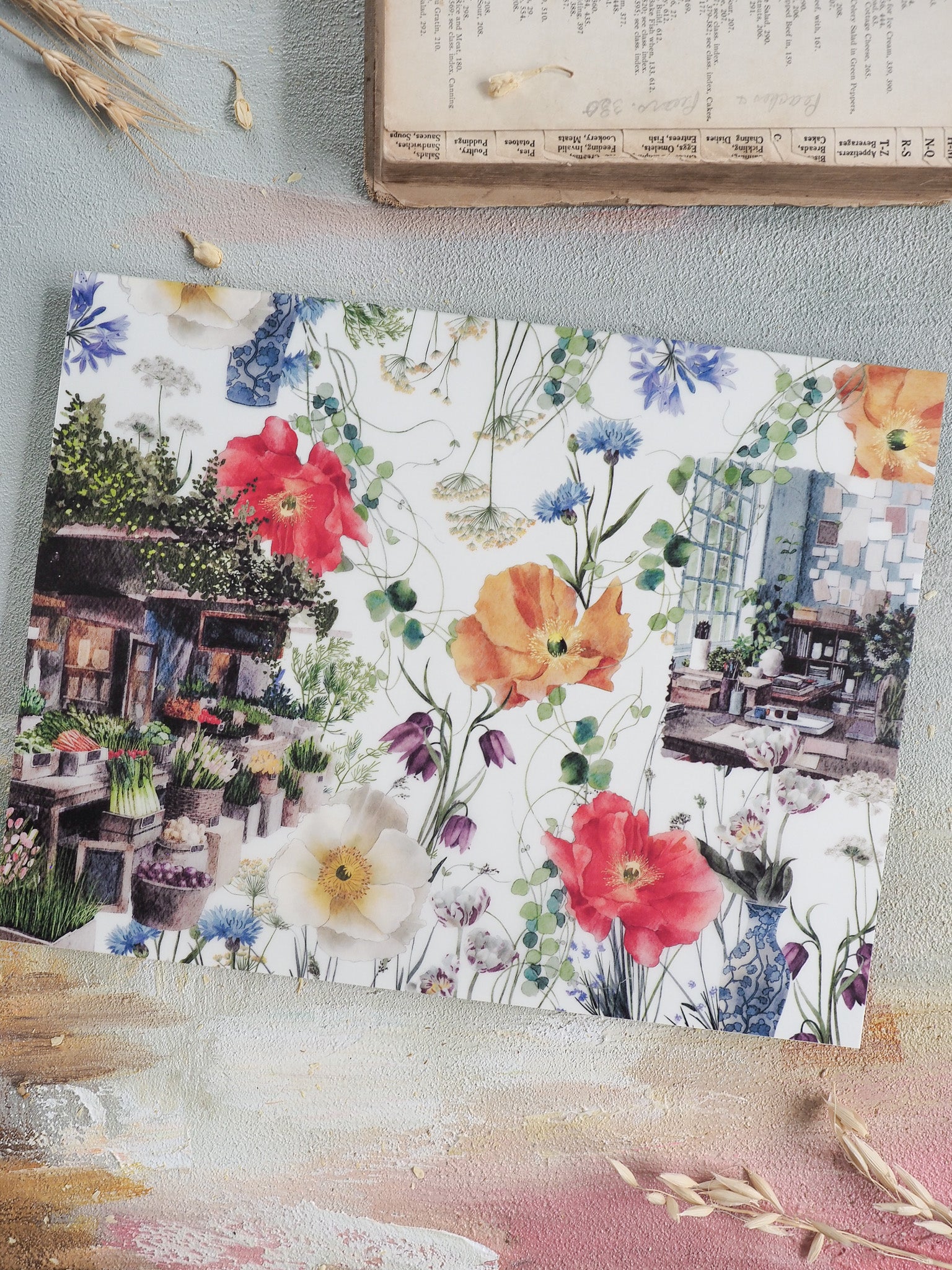 Detailed planner element for April 2026, featuring vibrant watercolor florals of red, yellow, and white over a picturesque European cafe backdrop.