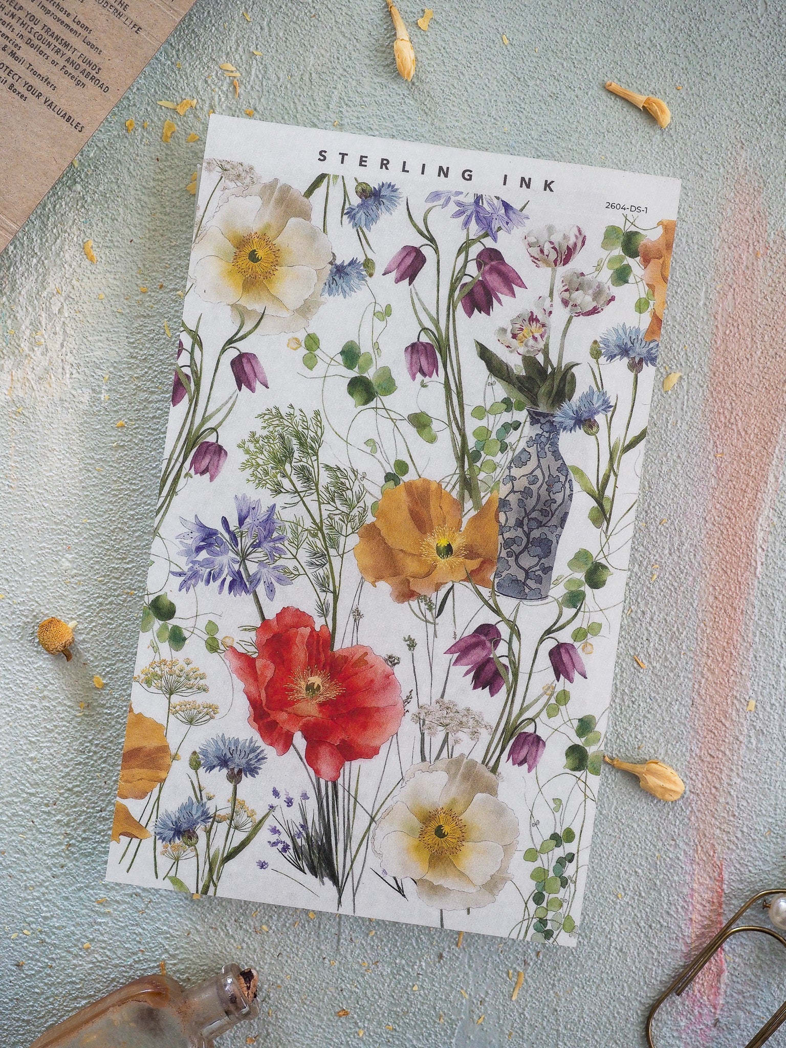 Elegant floral deco sheet for April 2026, featuring a watercolor bouquet design with vibrant red poppies, sunny yellow blooms, and deep purple and white blossoms.