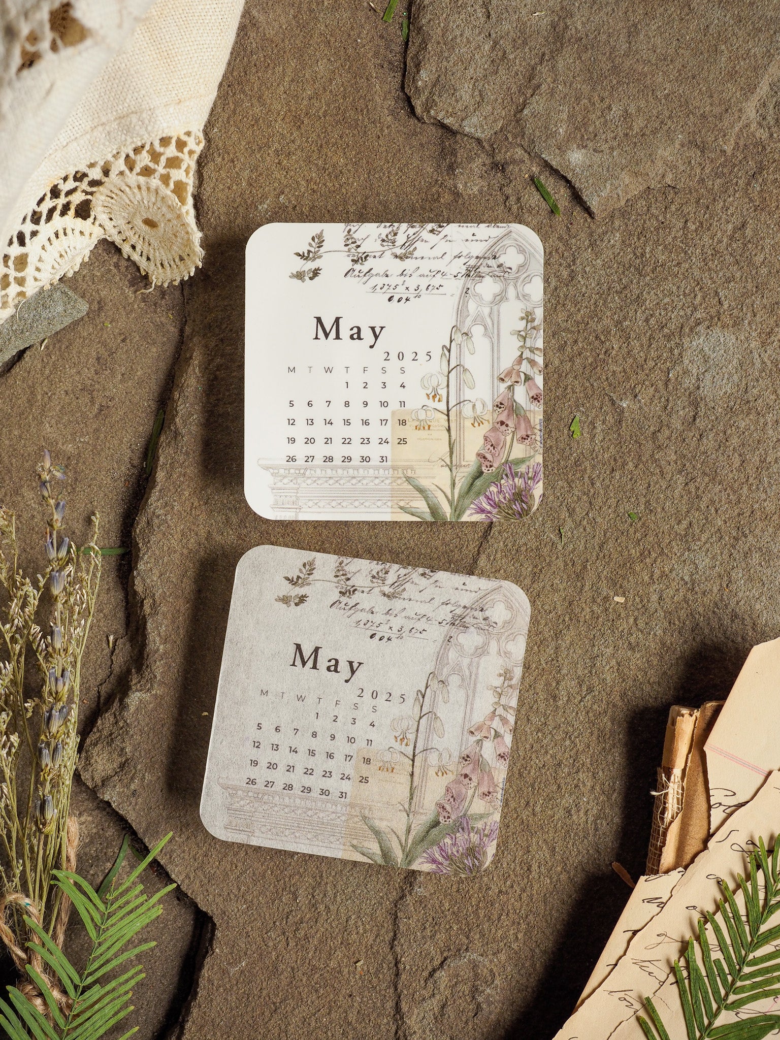 A vintage May 2025 monthly calendar featuring a delicate grid layout framed by soft watercolor botanical illustrations of lavender sprigs and muted greenery.