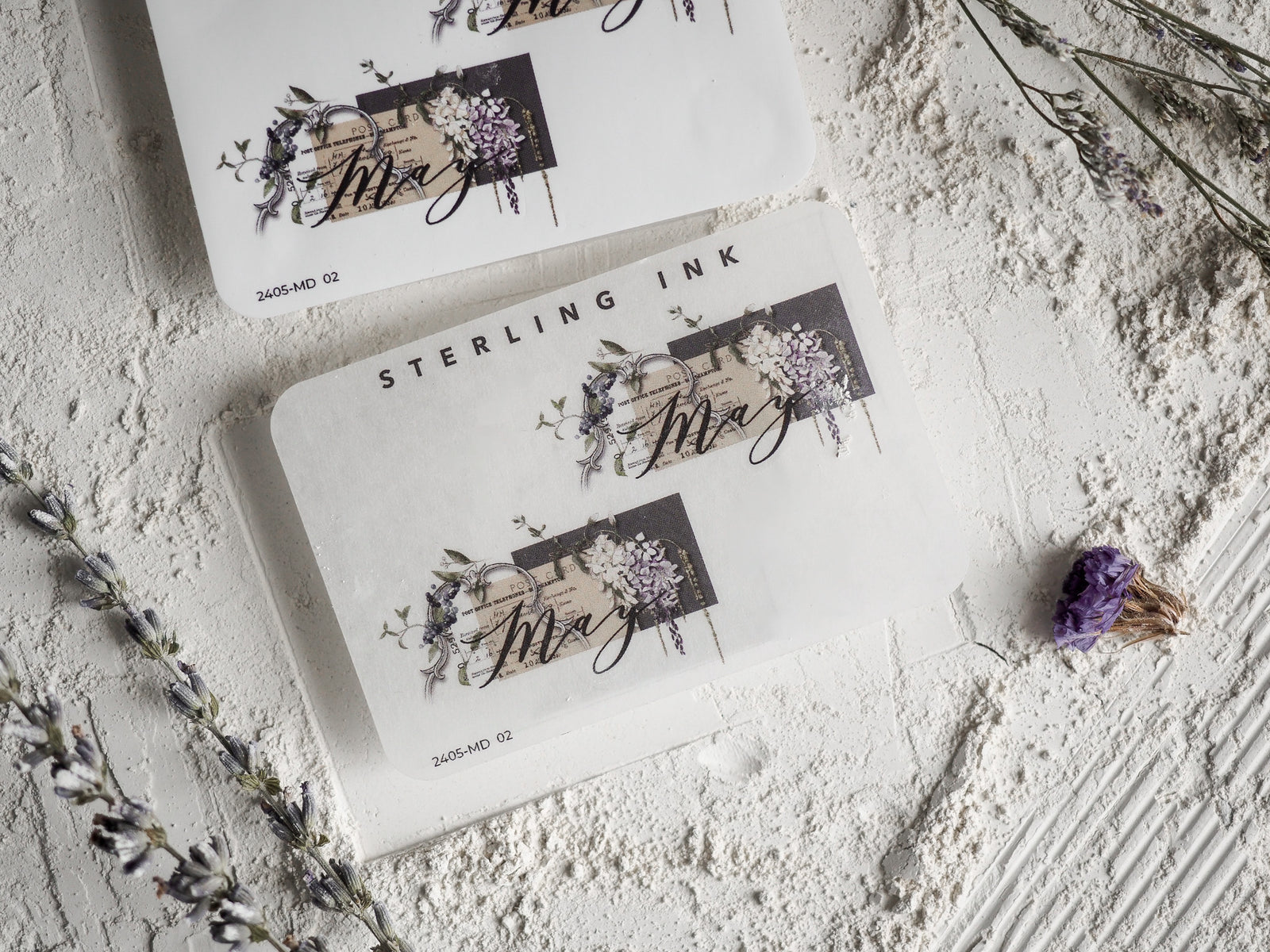 Elegant May month sticker featuring black script typography surrounded by delicate botanical and watercolor floral clusters.