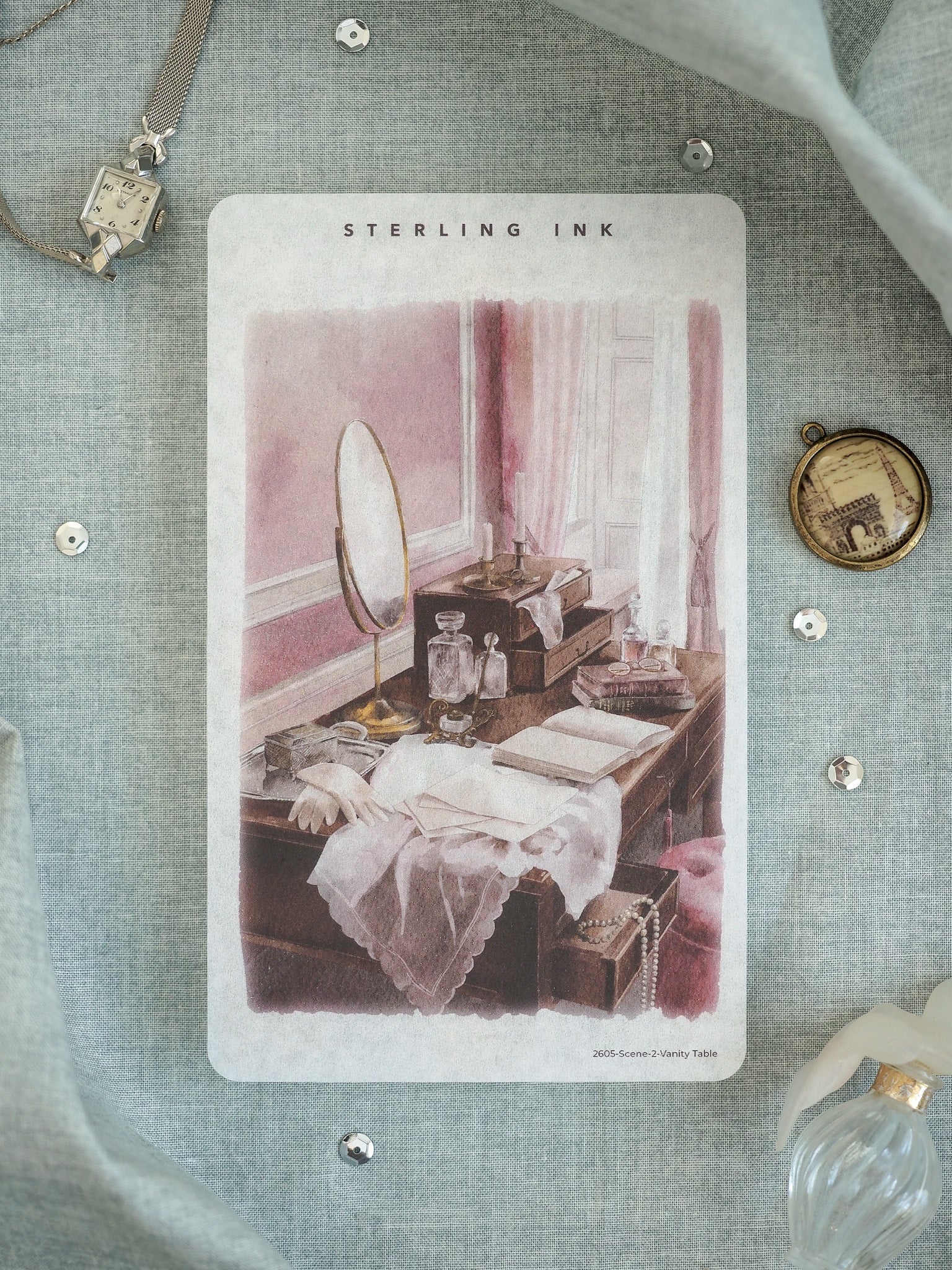Vintage print on a card featuring an elegant antique vanity table, adorned with a mirror, perfumes, stacked books, and draped fabrics.