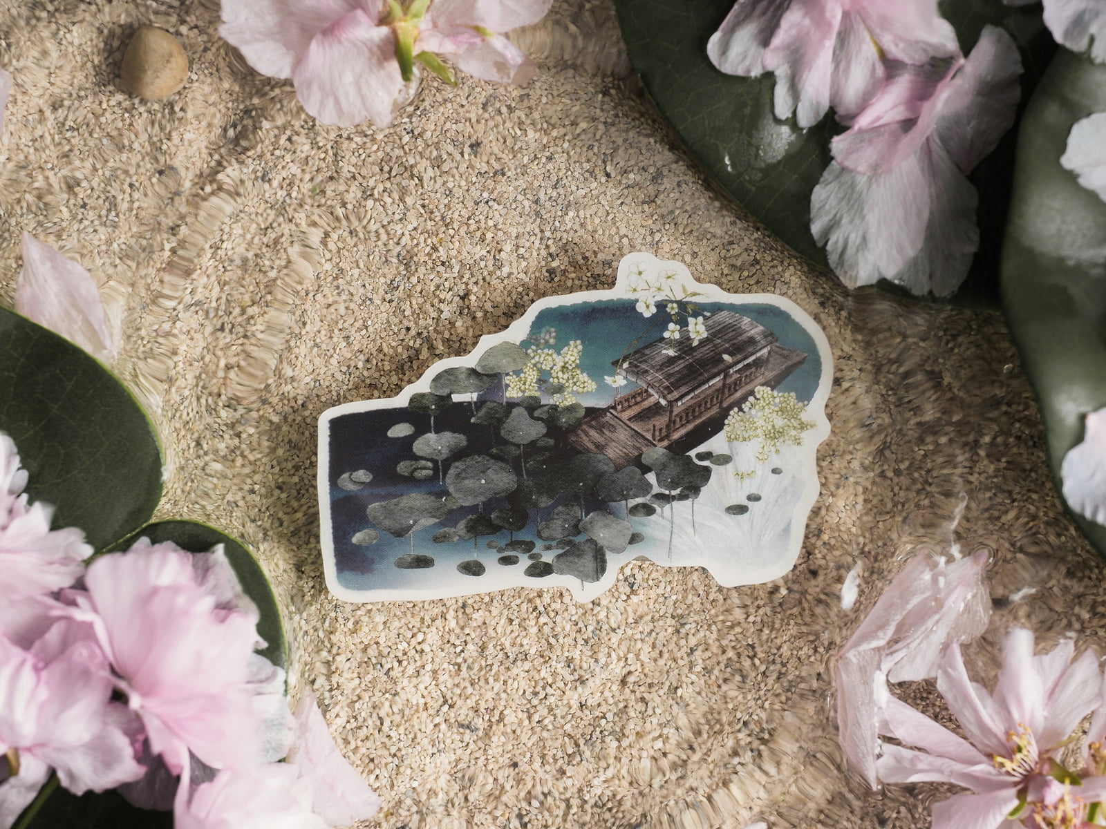 Die-cut vinyl sticker depicting a tranquil pond scene with a wooden boat floating amidst dark blue and white waterlilies.